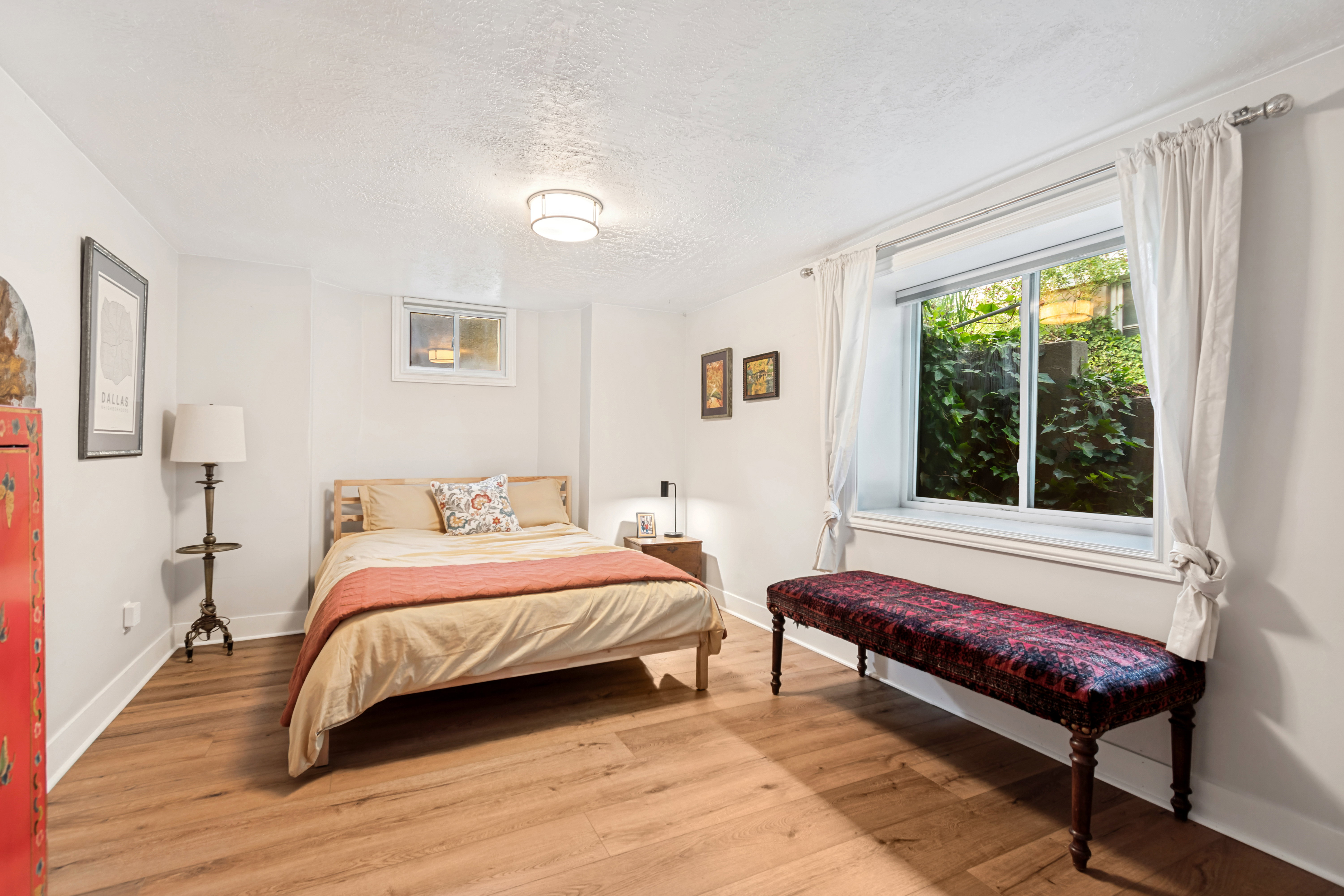 Bedroom featuring wood-finish flooring, white baseboards, and a contemporary ceiling light fixture