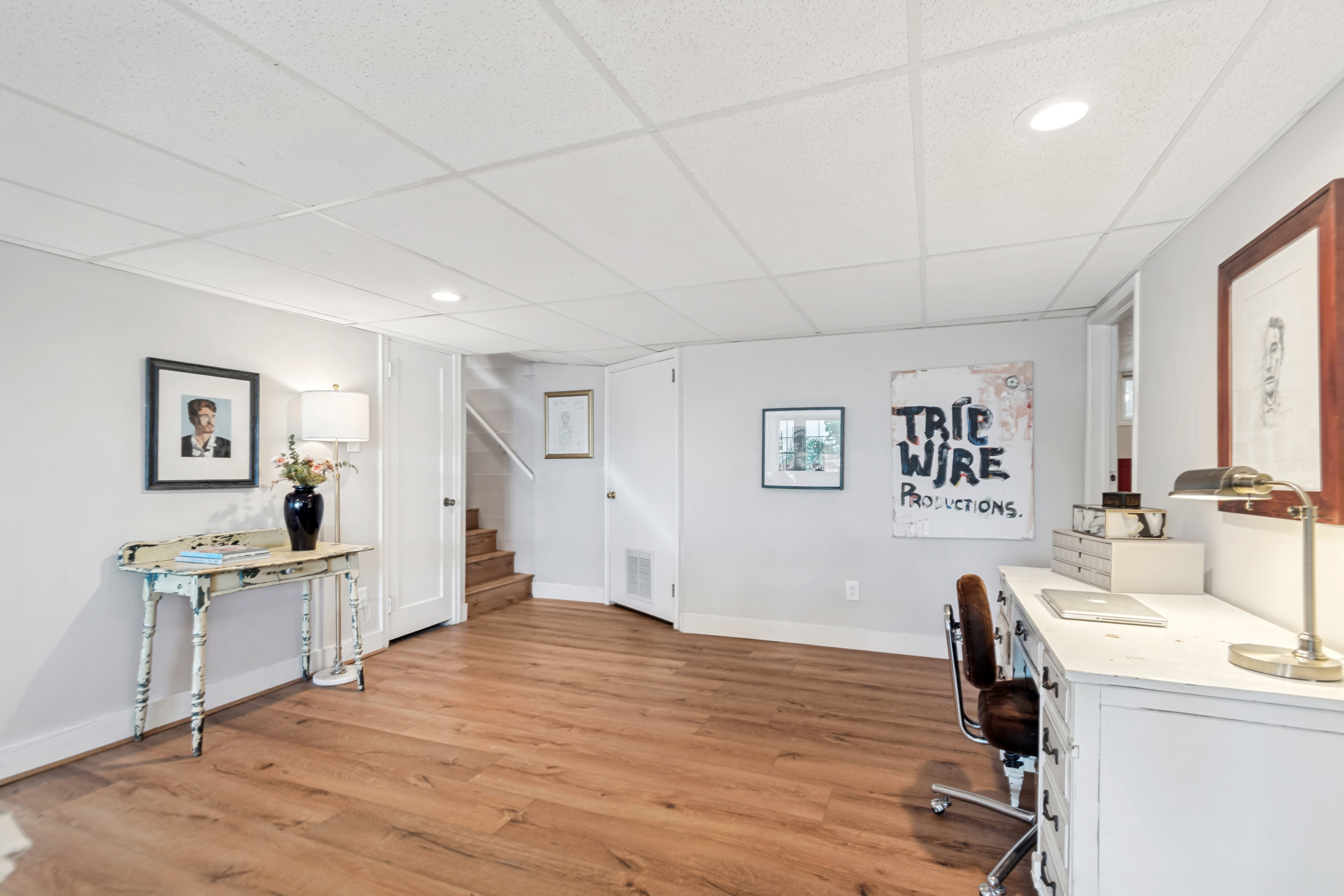 Spacious room featuring wood-finish flooring, light gray walls, white trim, recessed lighting, and a drop ceiling
