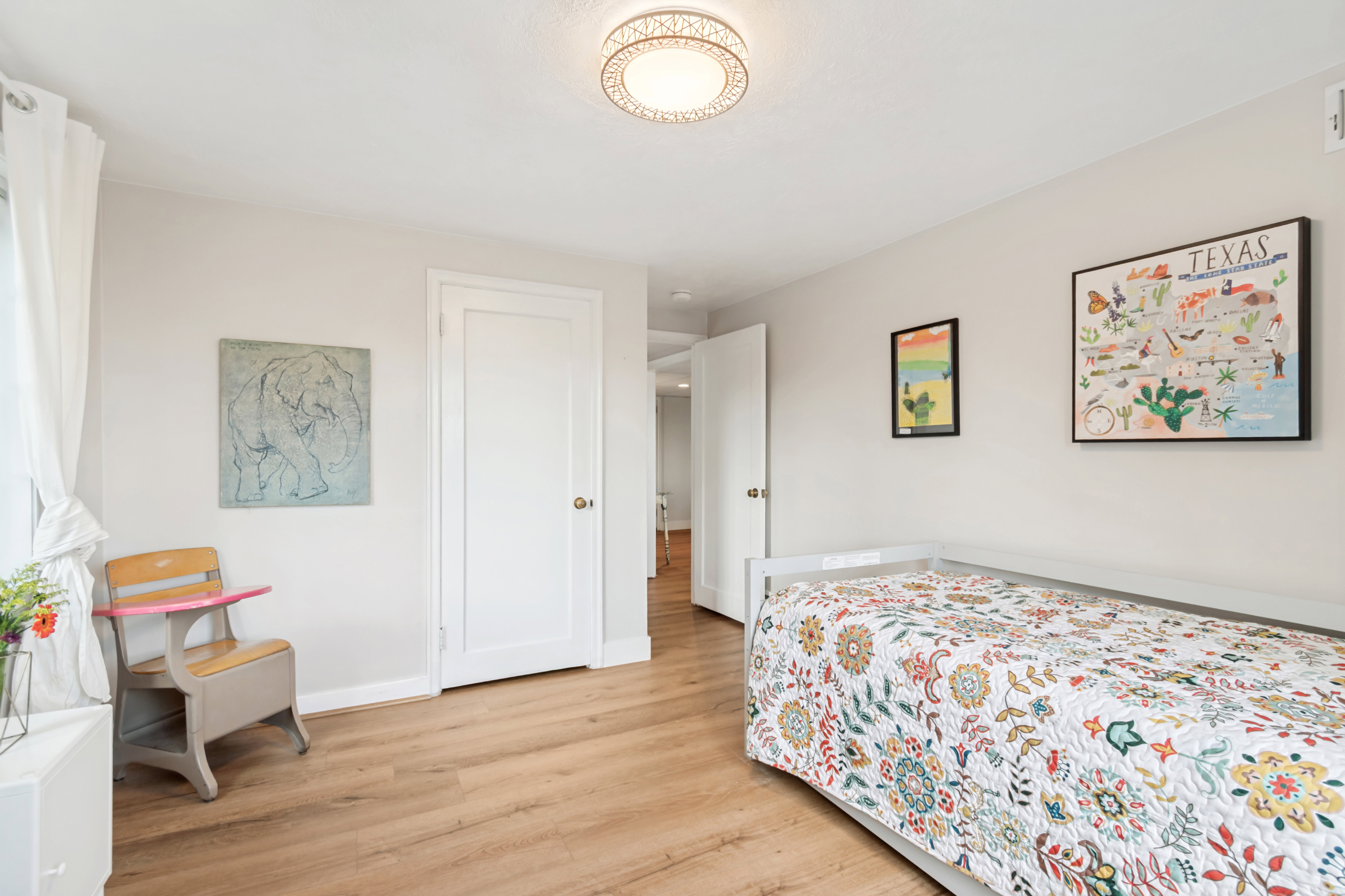 Interior room with wood-finish flooring, light neutral wall paint, and white baseboards