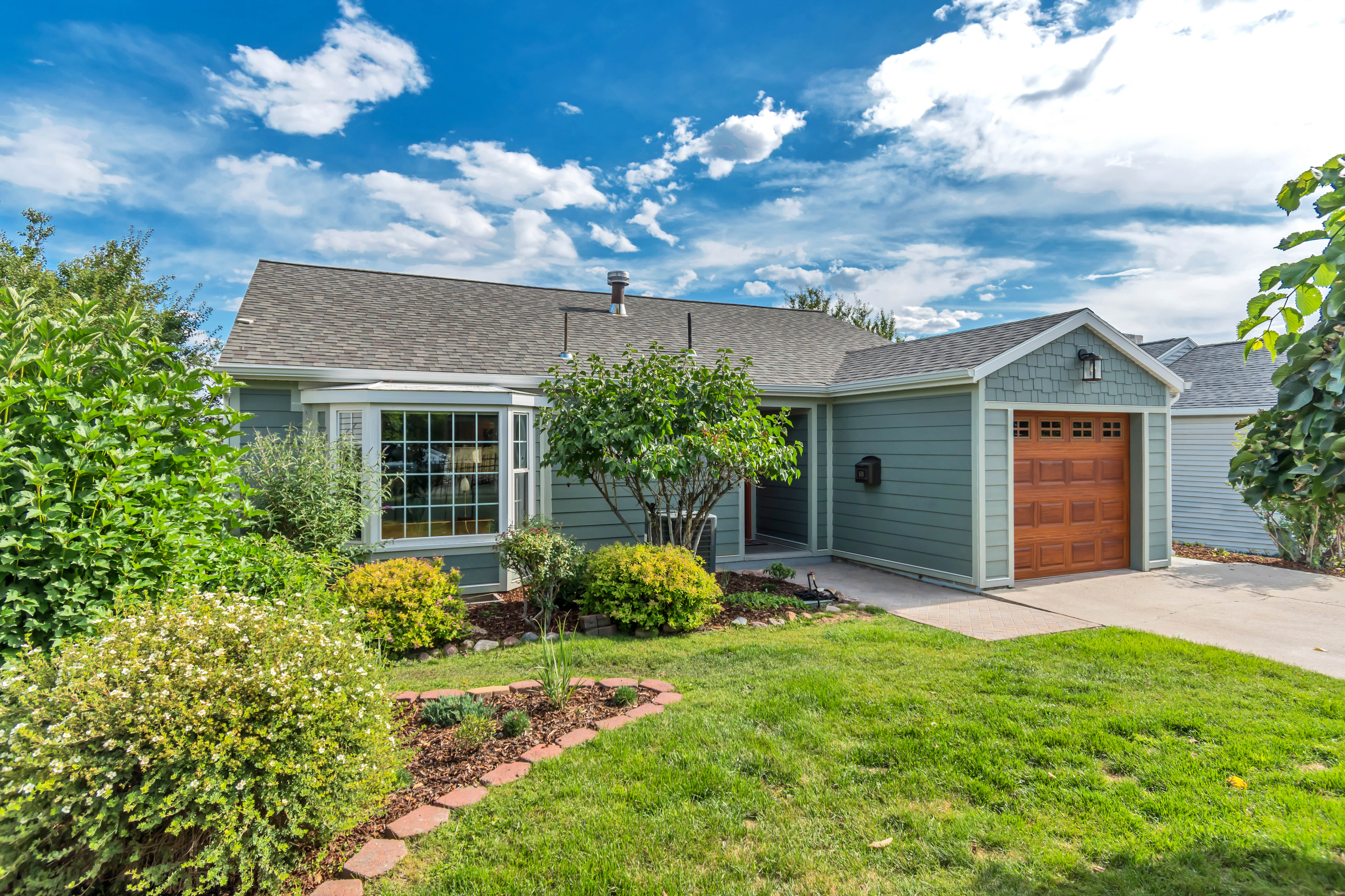 Ranch-style exterior with teal siding and a shingle roof