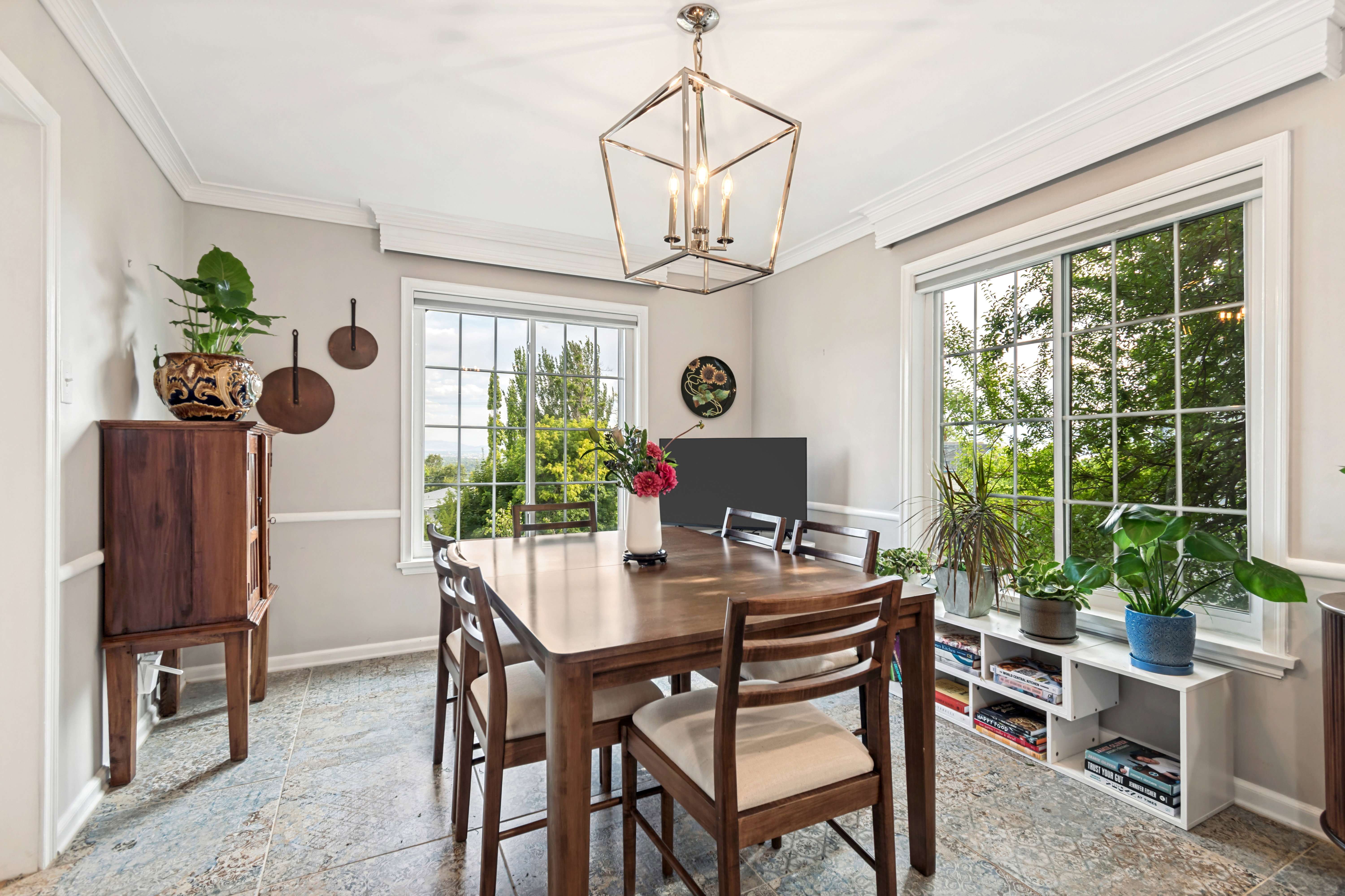 Dining area featuring large windows, crown molding, chair rail molding, and tile flooring