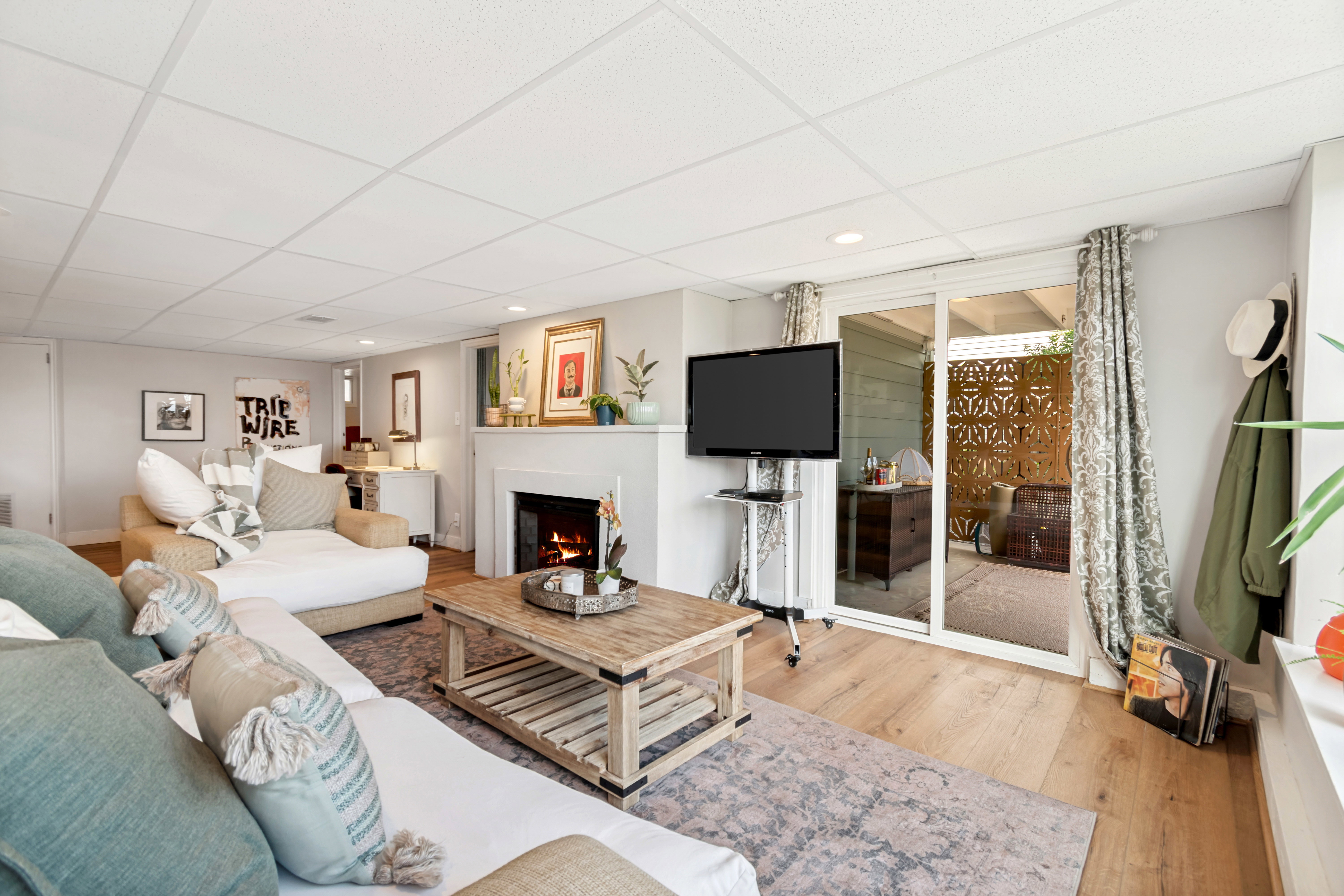 Living area featuring wood-finish flooring, a fireplace with a mantel, recessed lighting, and a drop-panel ceiling