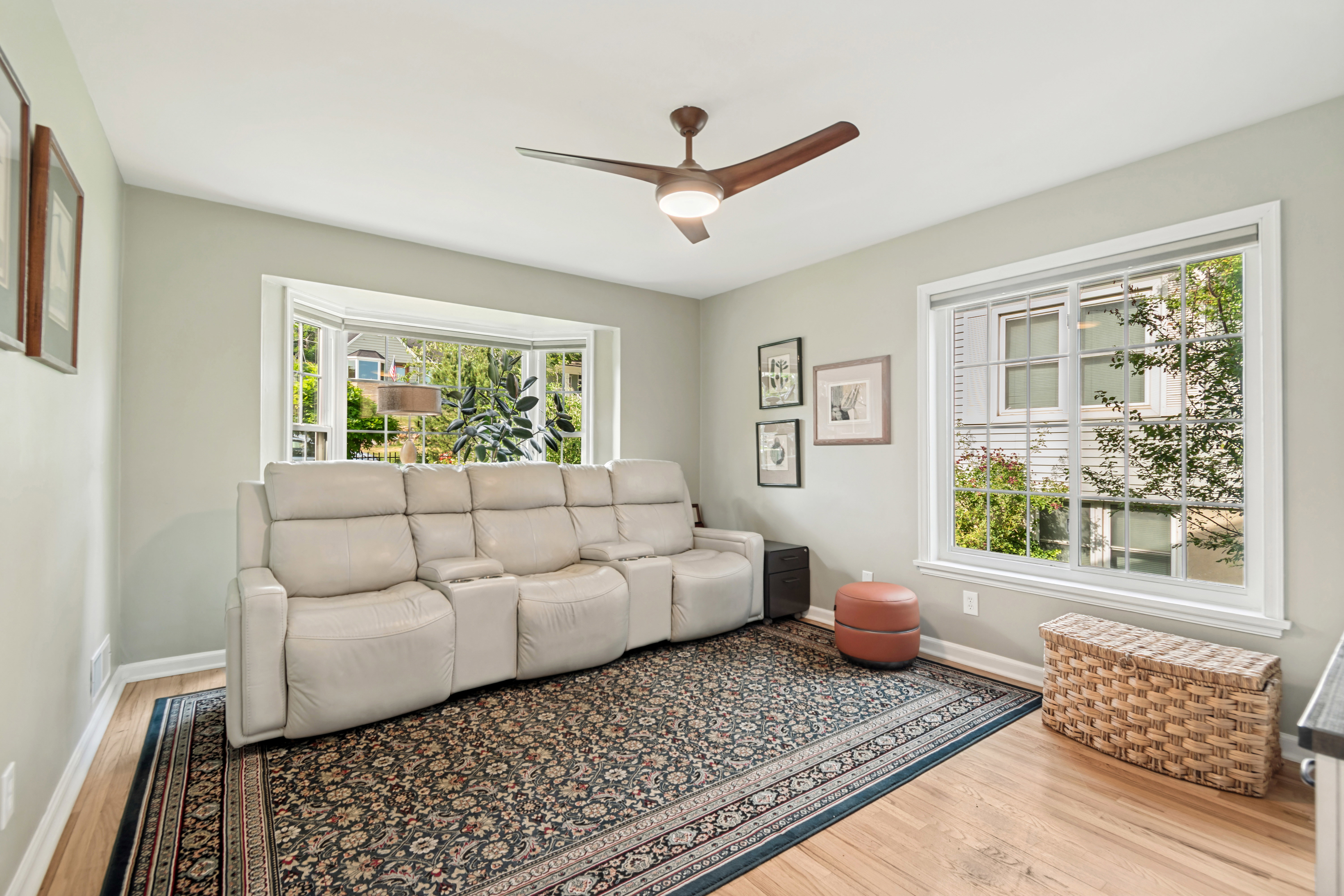 Spacious room featuring light wood-finish flooring and a bay window