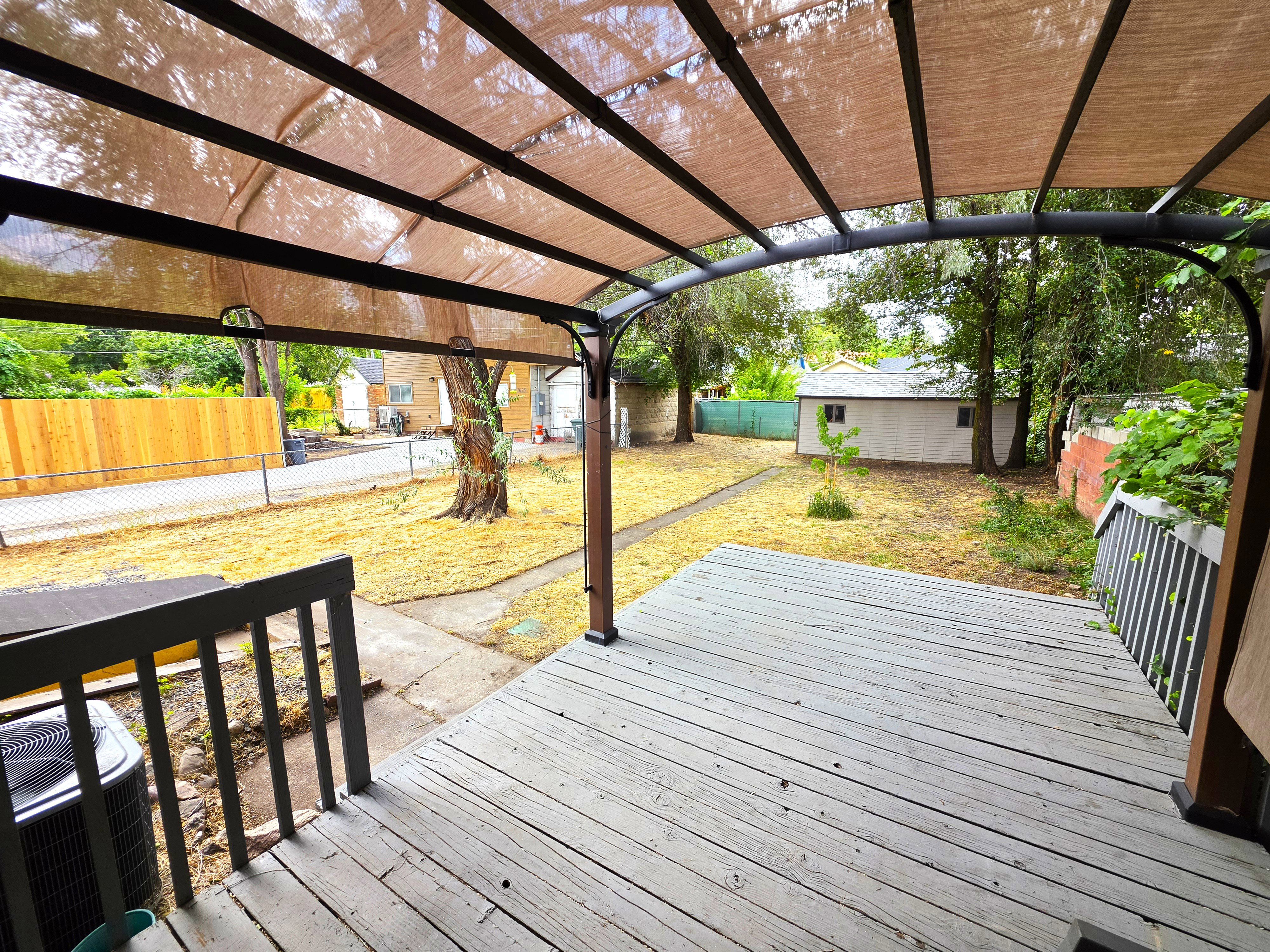 Outdoor deck with a metal pergola featuring a fabric canopy