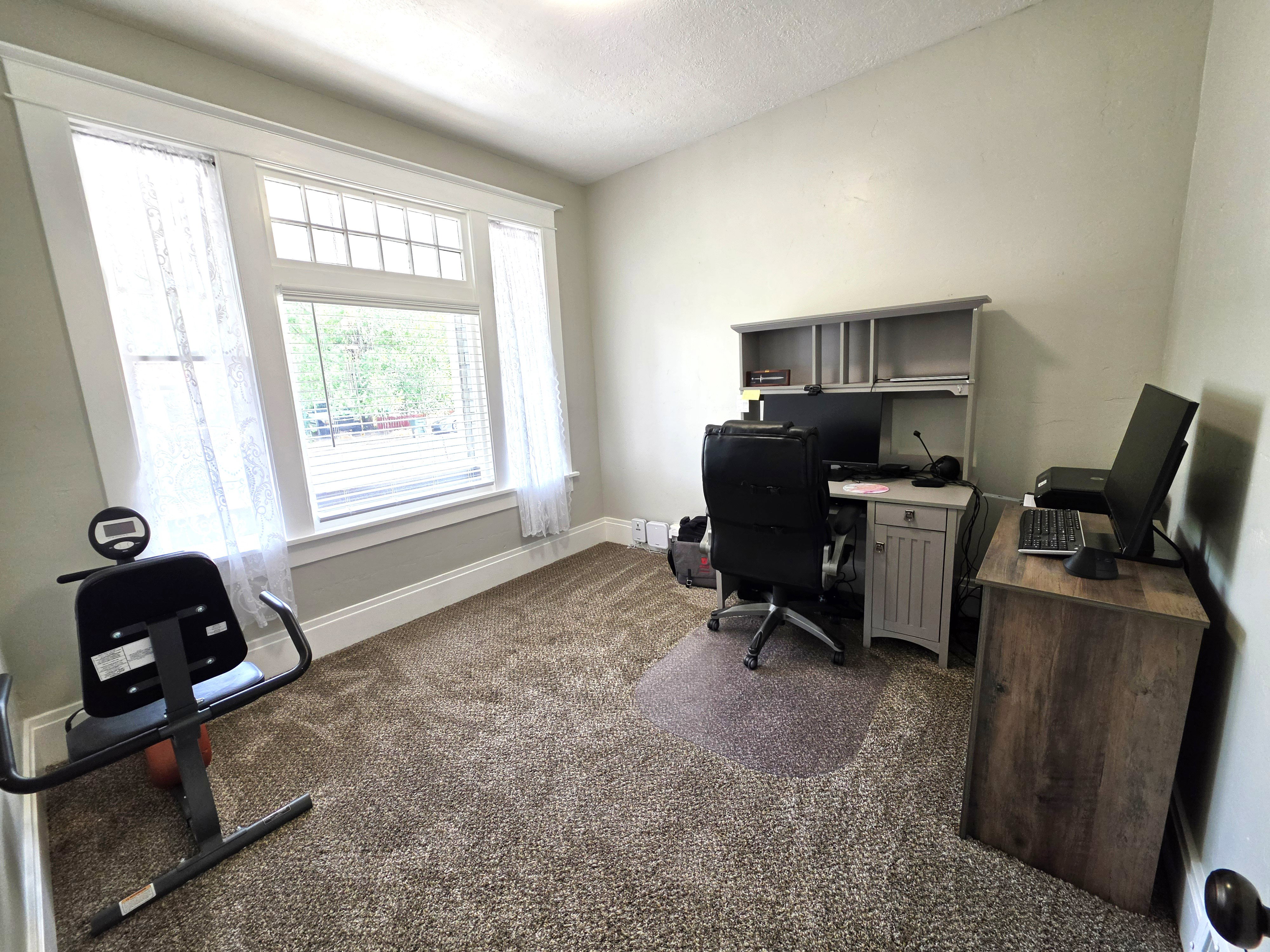 Room featuring a large window with transom, white trim, and light gray walls