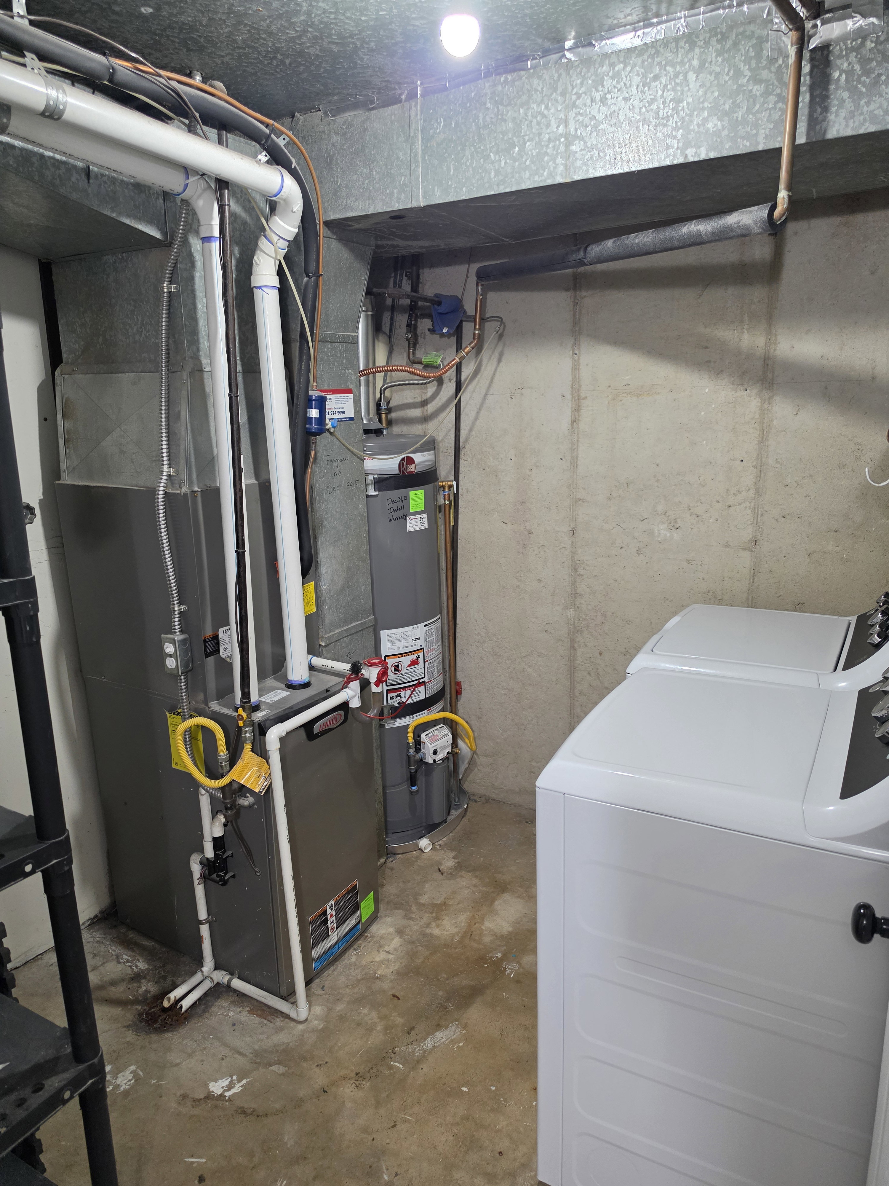 Utility area featuring a water heater, furnace, and laundry appliance