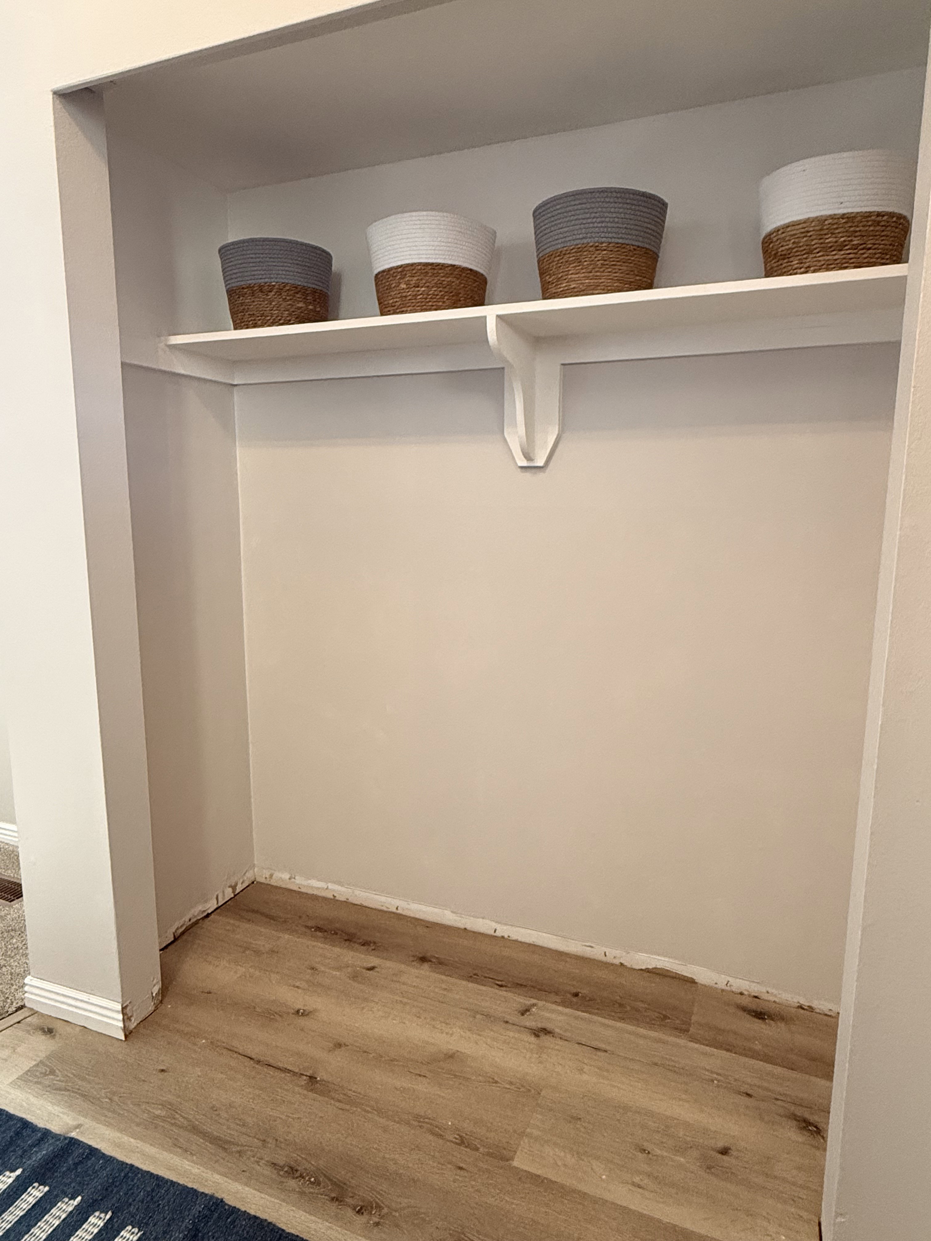Recessed alcove with integrated shelving, wood-finish flooring, and neutral wall tones