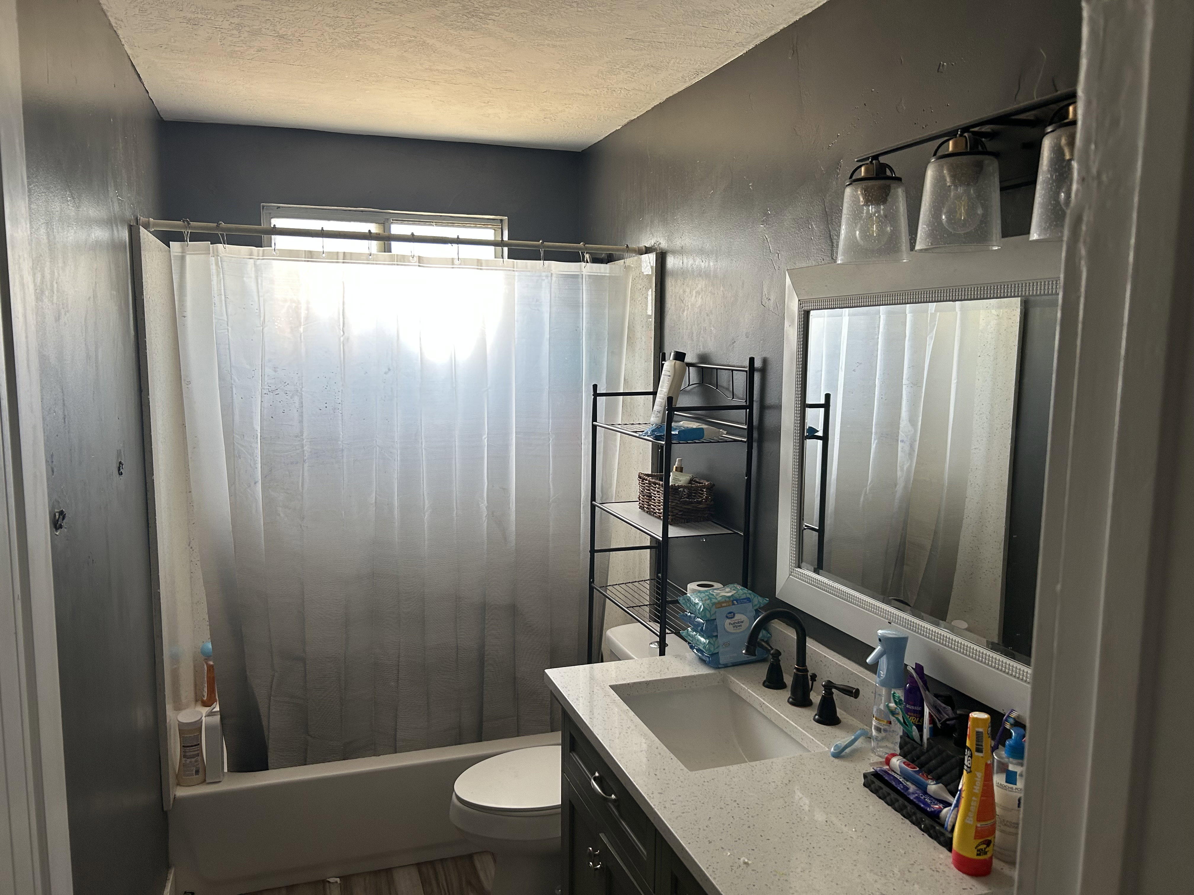 Bathroom featuring a vanity with quartz-finish countertop and undermount sink, dark-finish cabinetry, and black-finish faucet