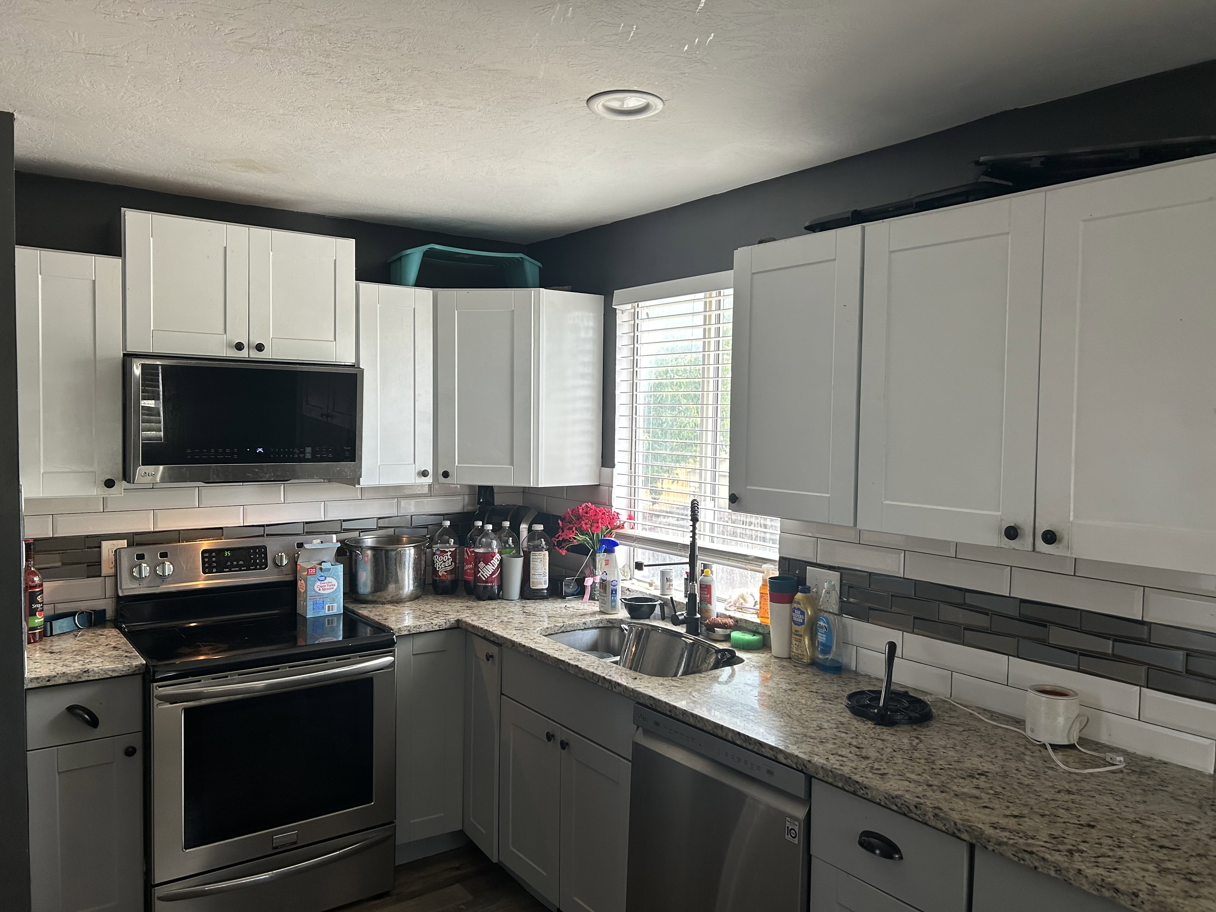 Modern kitchen featuring white upper cabinetry and gray lower cabinetry