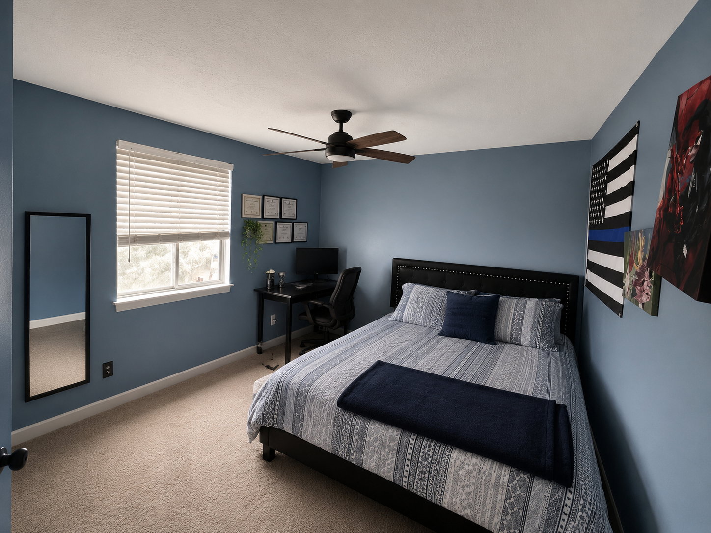 Comfortable sleeping area with a window, textured carpet flooring, and a ceiling fan