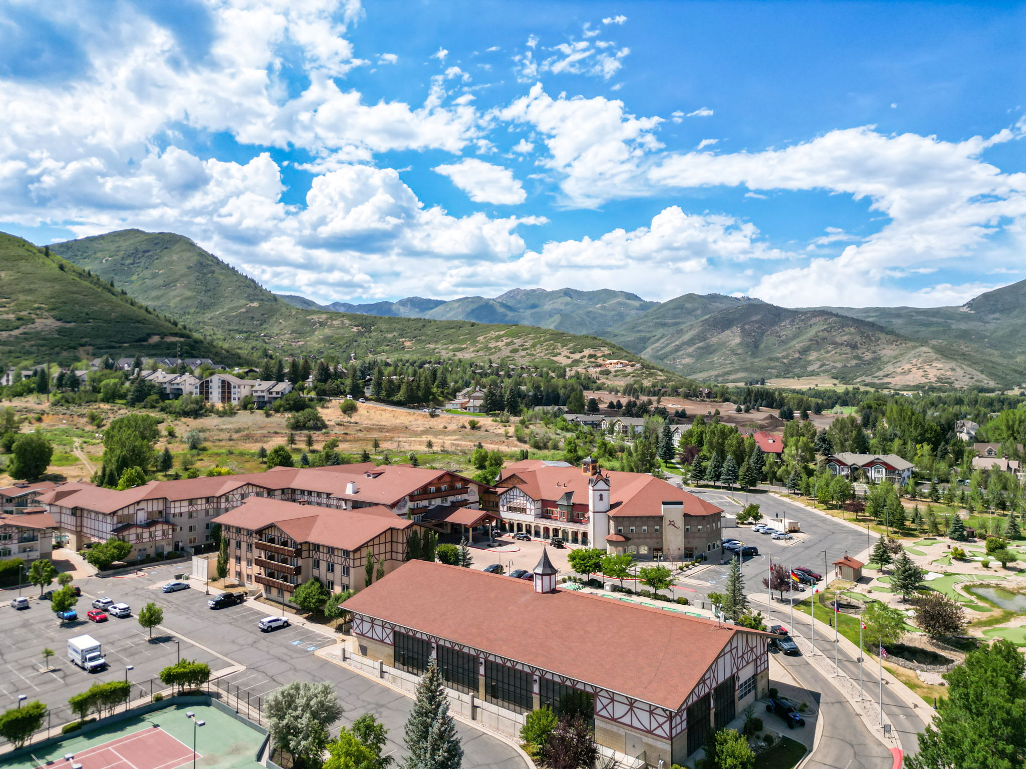 Expansive resort-style property showcasing multiple buildings with chalet-style architecture, red tile roofs, and exterior wood beam detailing