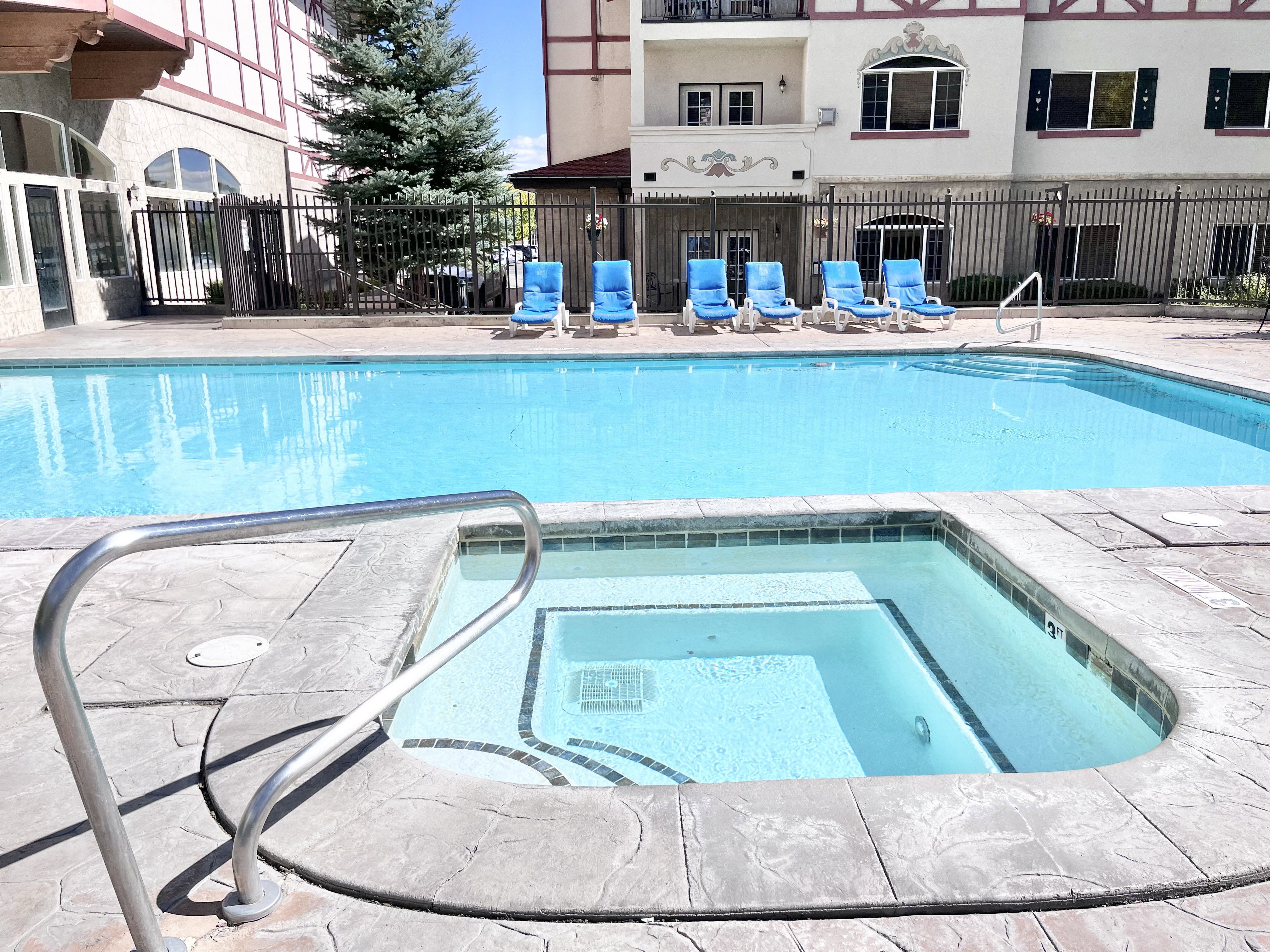 Resort-style pool area featuring a rectangular pool and an integrated hot tub