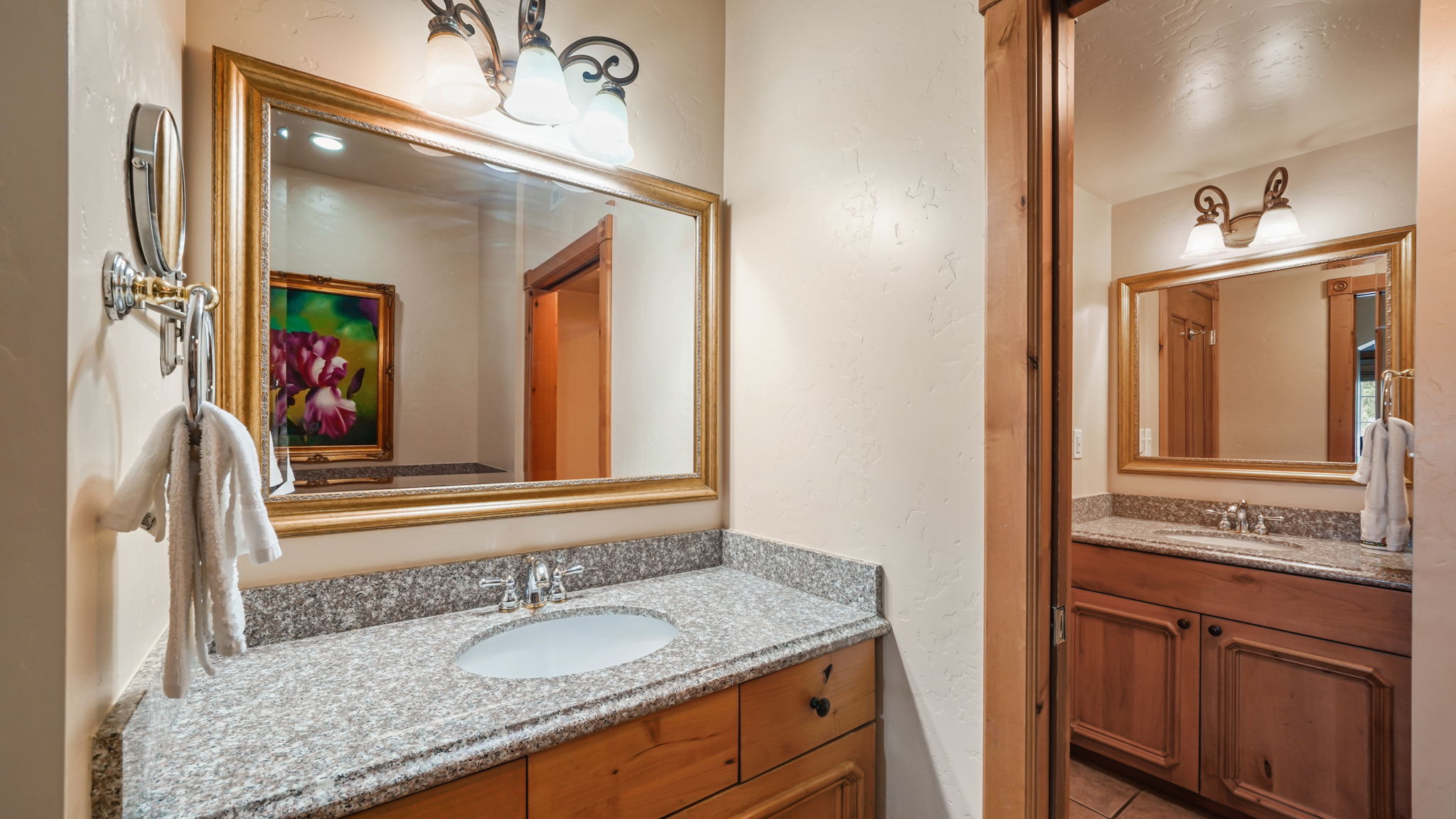 Vanity with a granite countertop, undermount sink, and wood cabinetry