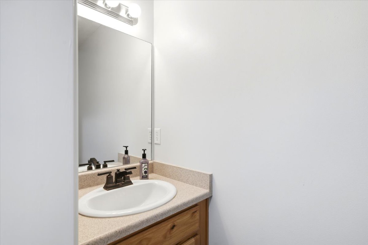 Vanity featuring a drop-in sink, dark bronze faucet, and a light-colored countertop