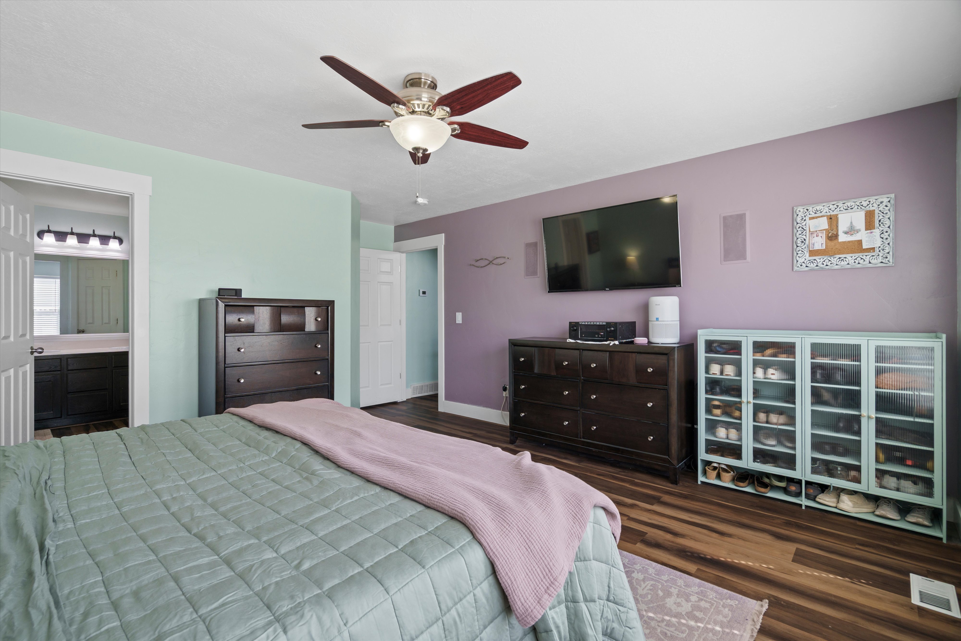 Room with wood-finish flooring, a ceiling fan, and built-in speakers