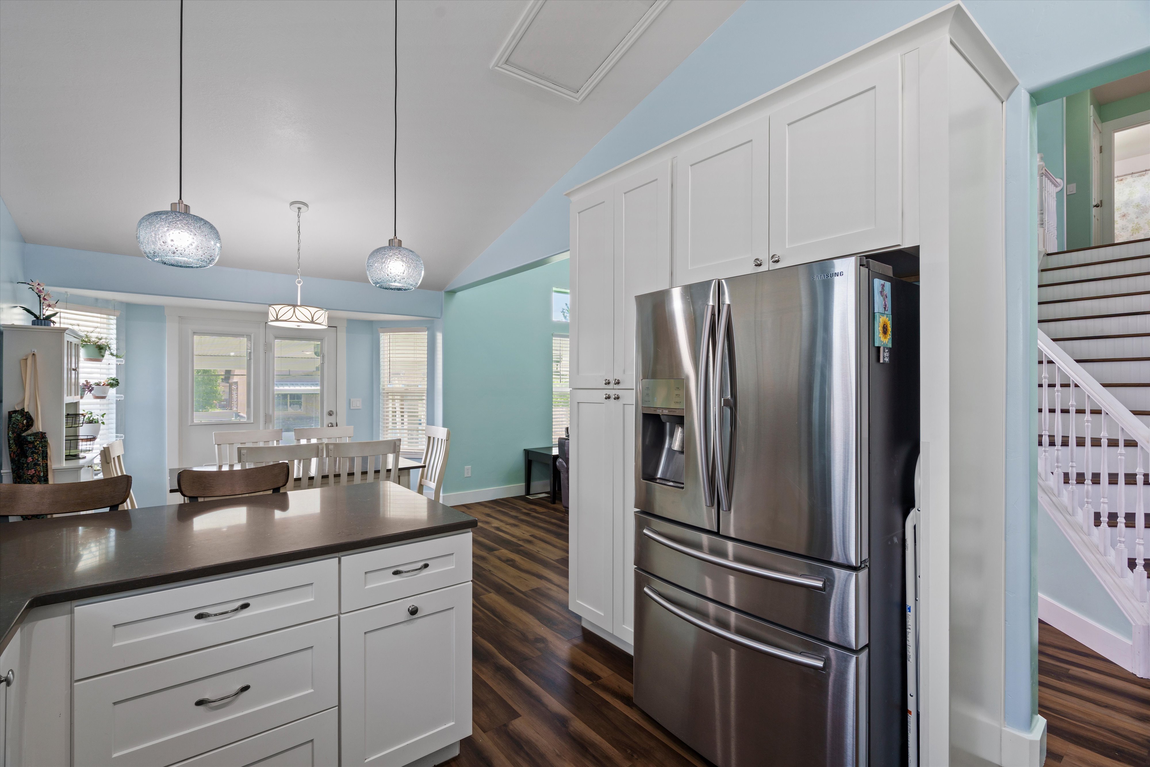 Kitchen island with a dark countertop and white cabinetry, complemented by two pendant lights