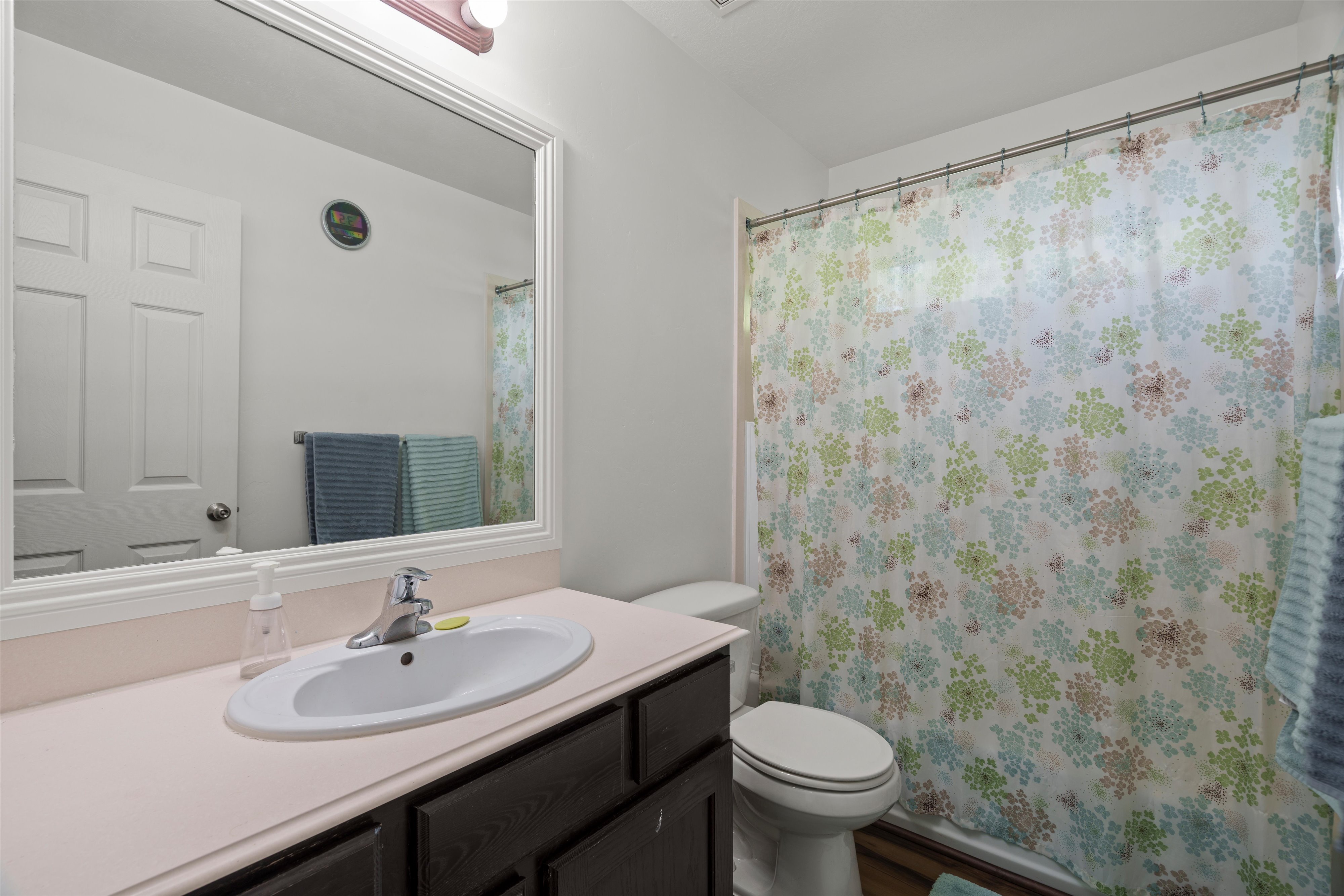 Bathroom vanity featuring an integrated oval sink, chrome faucet, and a large framed mirror with overhead lighting