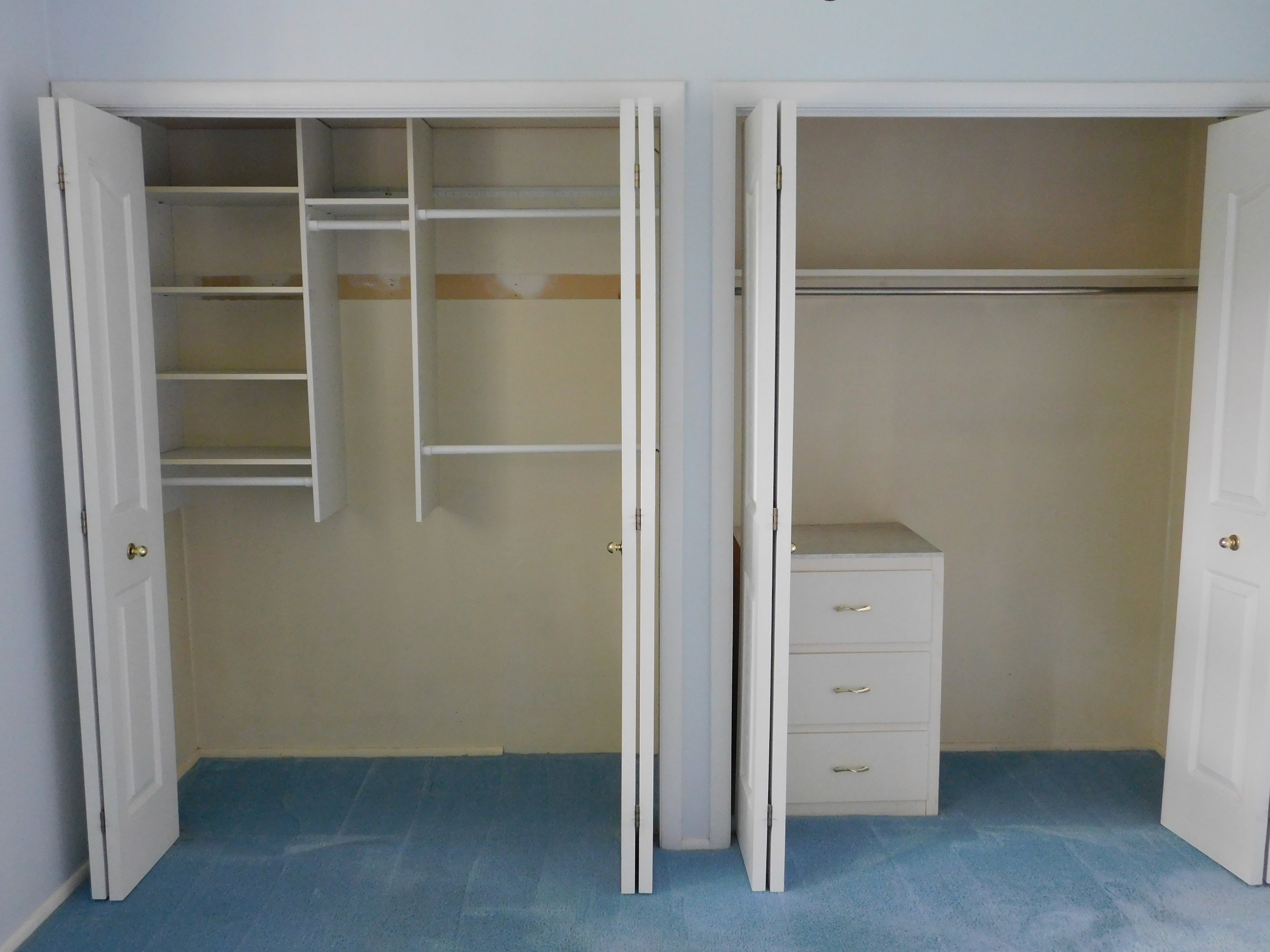 Dual closet spaces featuring bi-fold doors, white shelving, and hanging rods