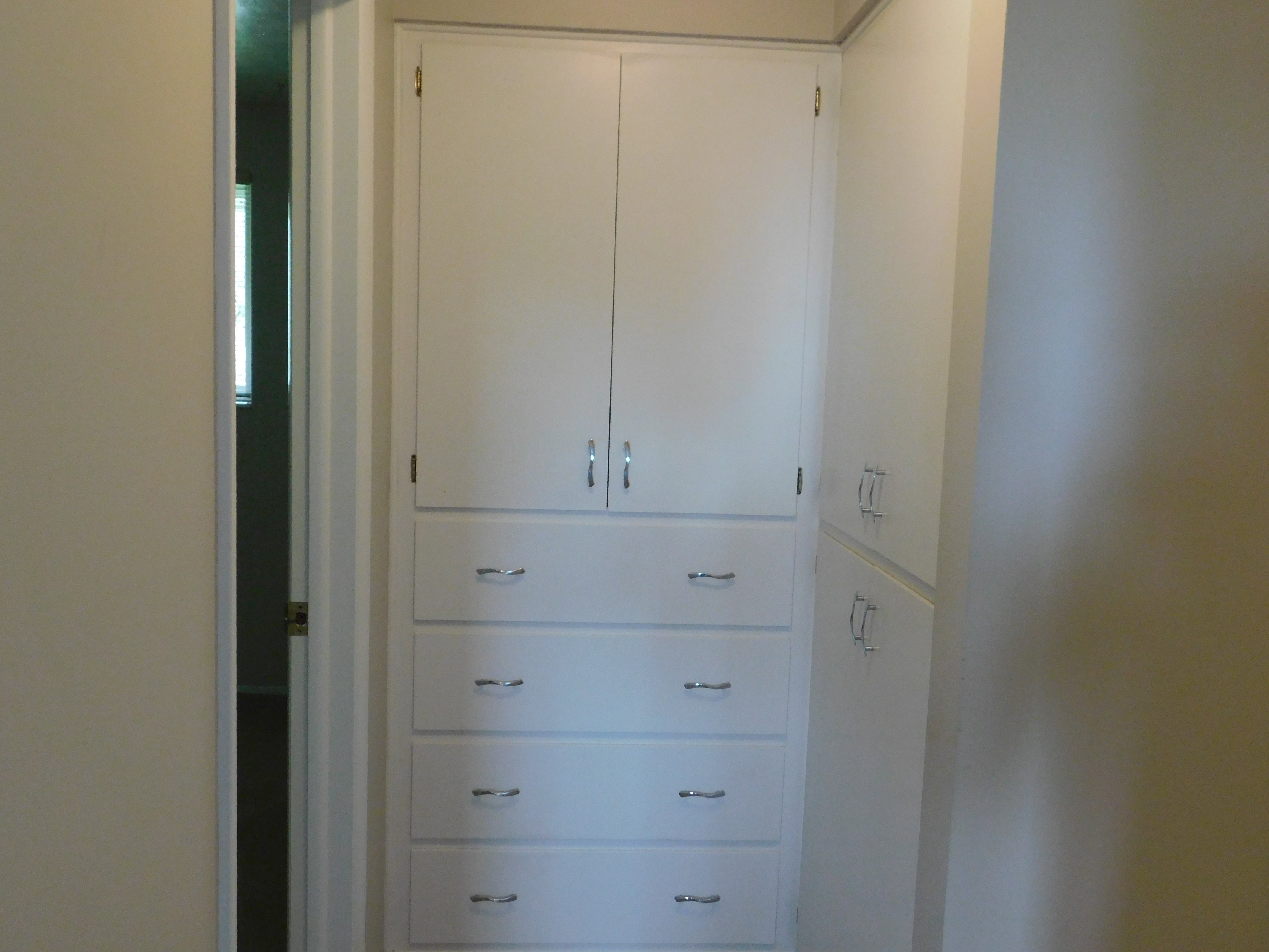 Built-in cabinetry featuring white finishes and chrome hardware