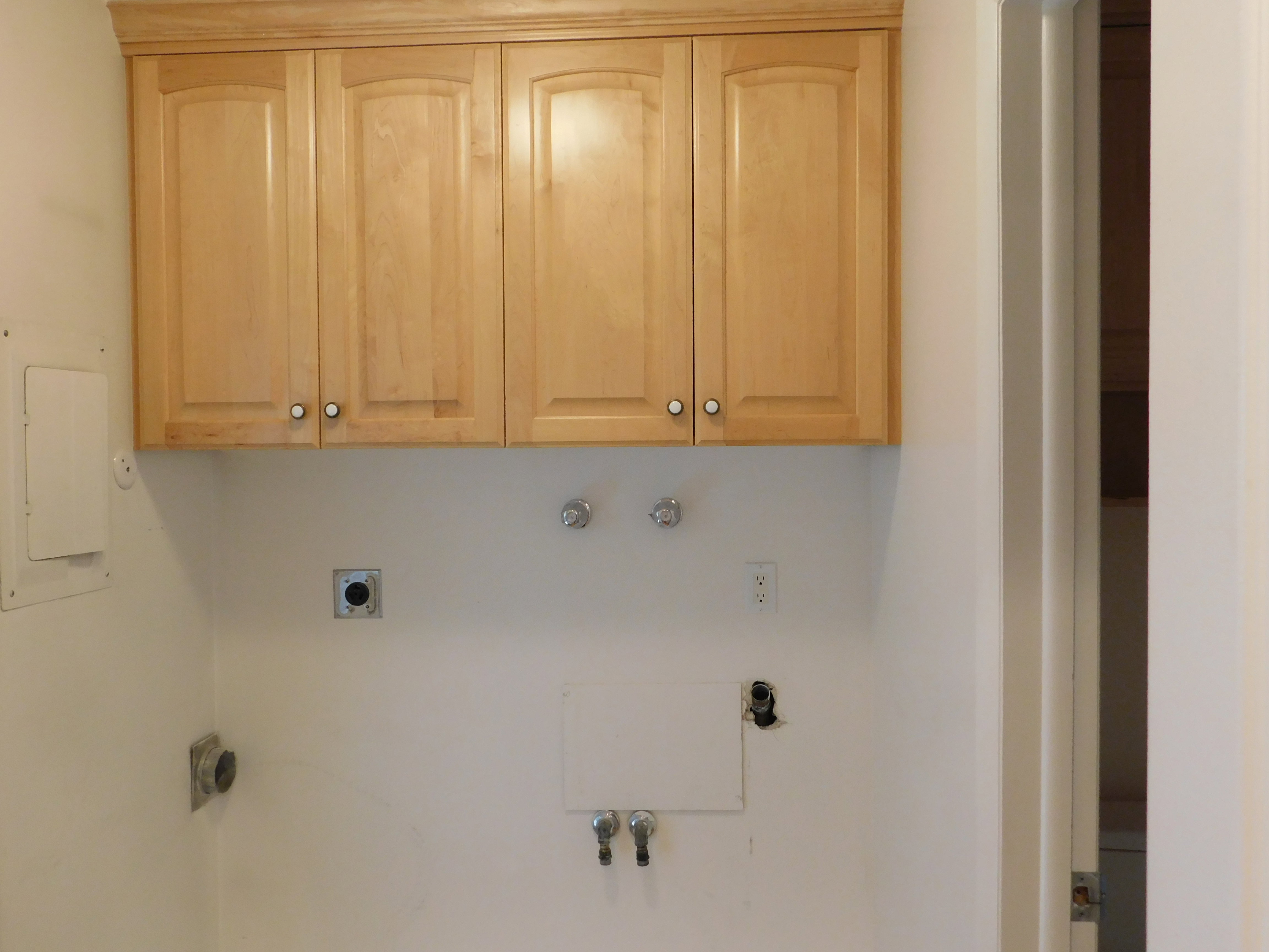 Upper cabinetry with light wood finish and crown molding detail