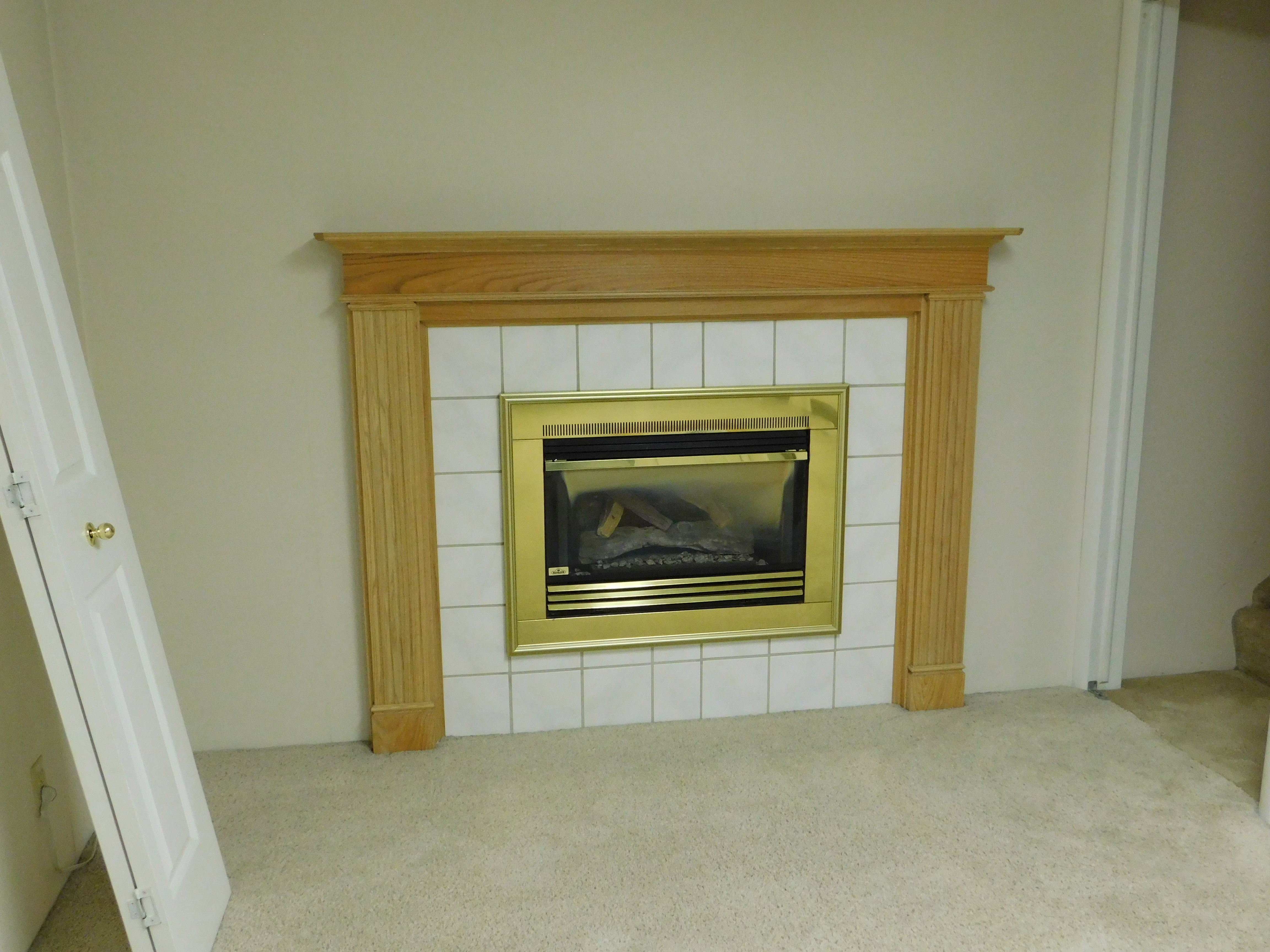 Built-in fireplace featuring a brass surround, white tile hearth, and a wood mantel