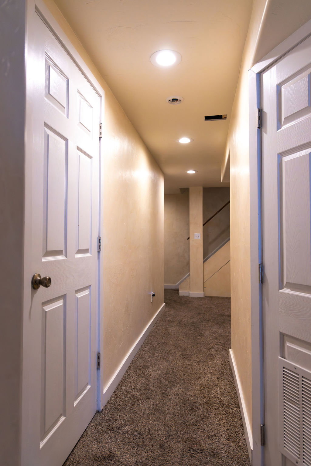 Carpeted hallway featuring recessed lighting and white paneled doors