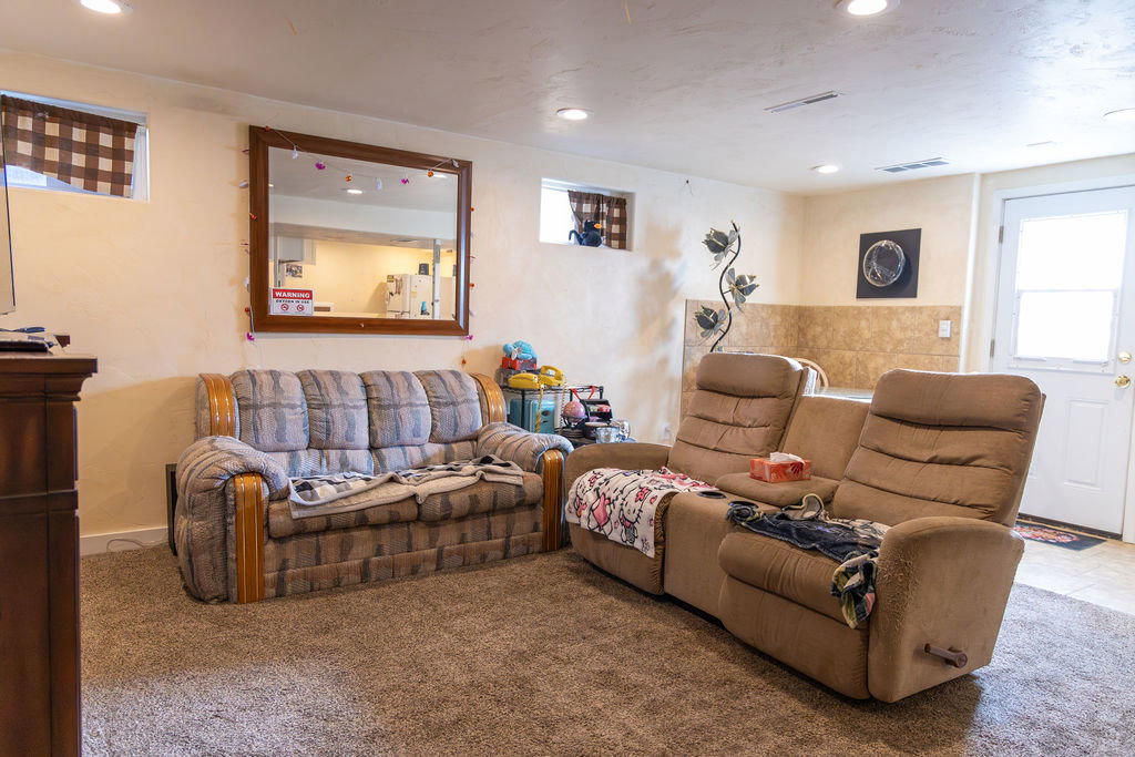 Carpeted room featuring recessed lighting, a window with horizontal blinds, and a paneled door with a window insert