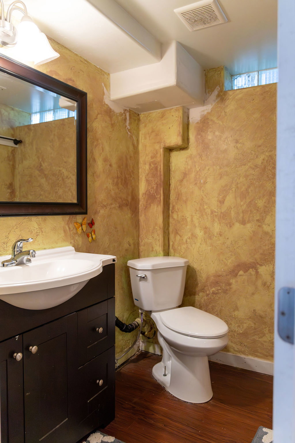 Bathroom featuring a contemporary vanity with an integrated sink, dark wood-finish cabinetry, and wood-finish flooring