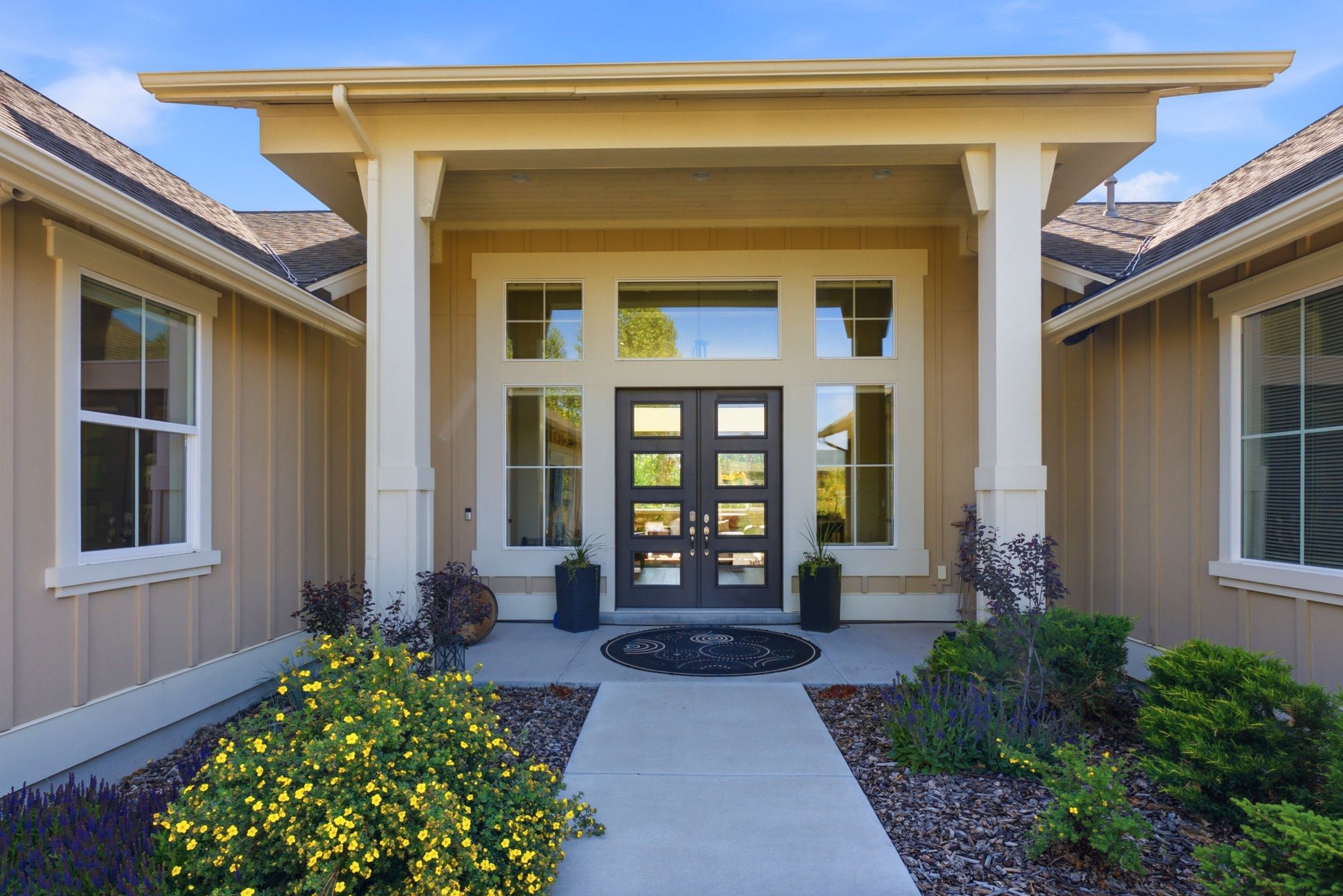 Spacious covered entry with dual pane windows and a modern double door