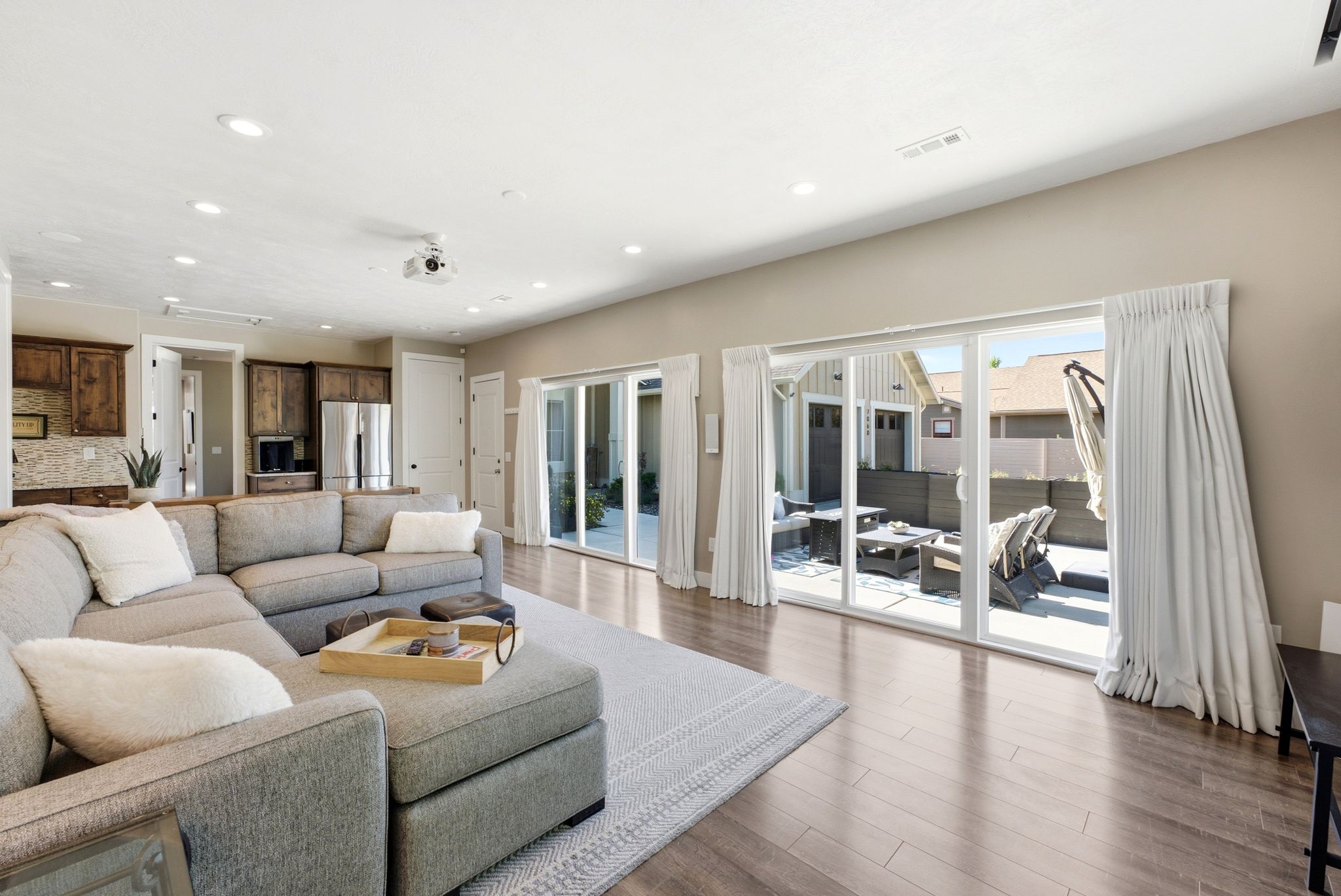 Open-concept living area featuring wood-finish flooring, recessed lighting, and a built-in projector