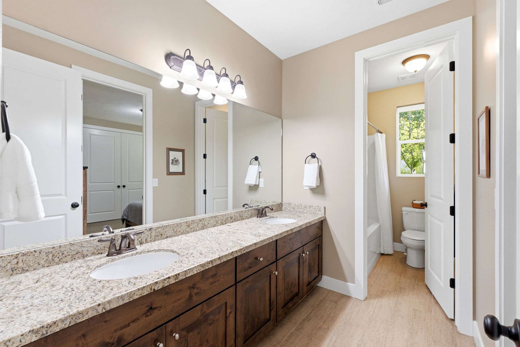 Dual vanity with granite-style countertop and dark wood cabinetry