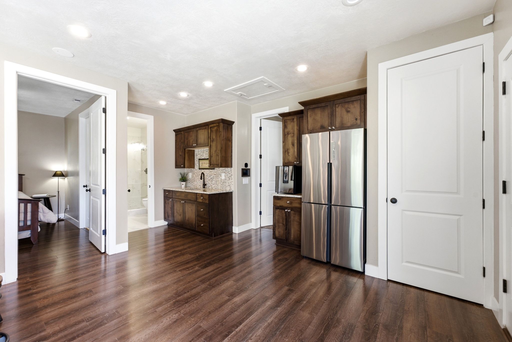 Spacious room featuring wood-finish flooring, recessed lighting, and white trim