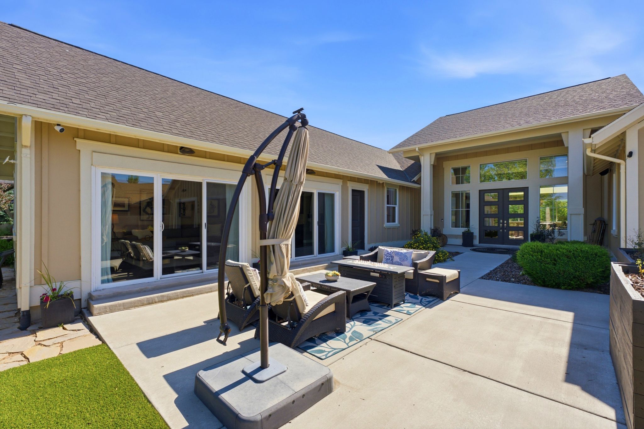 Expansive concrete patio offering multiple access points to the residence