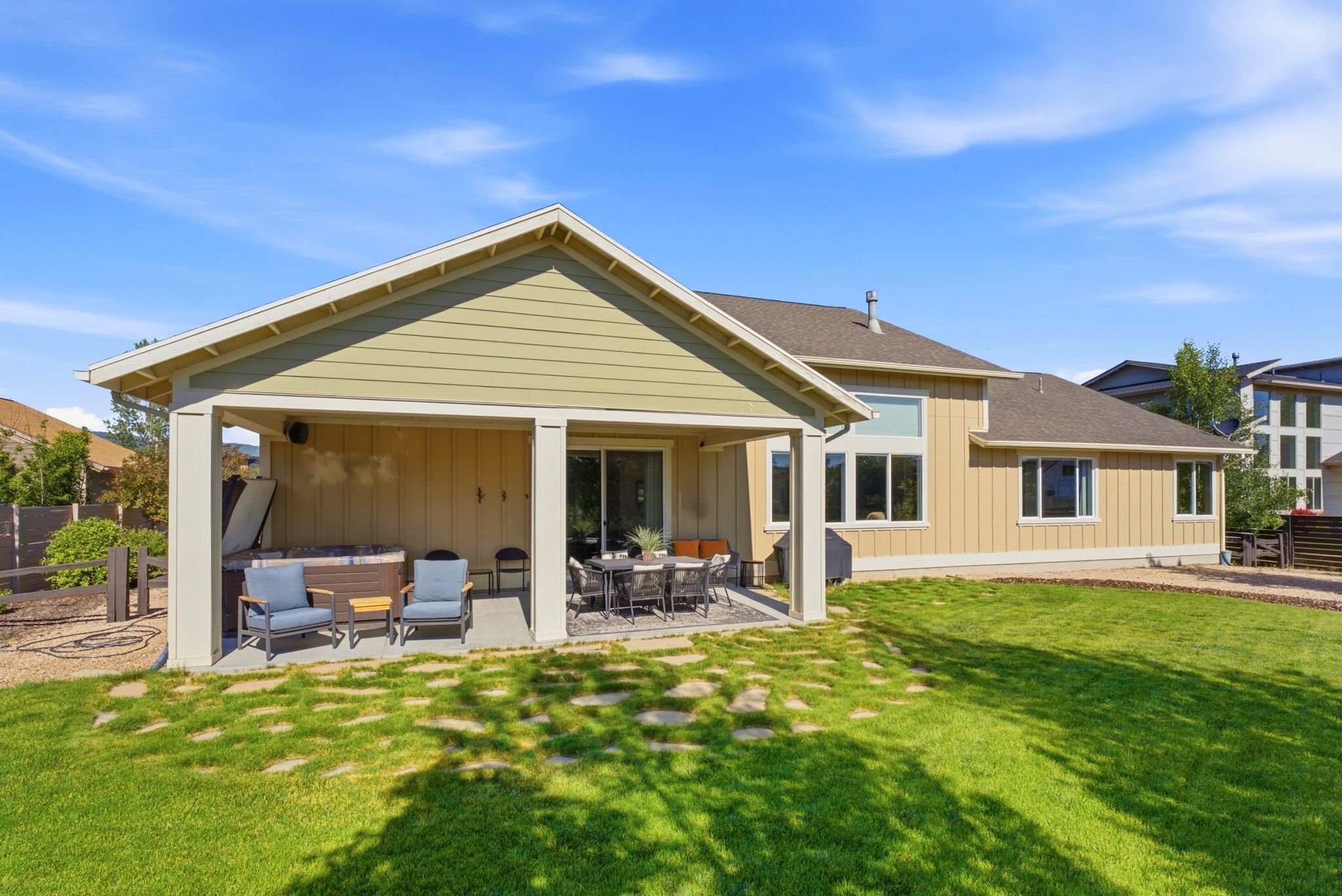 Covered patio area featuring a built-in spa, concrete patio, and a sliding glass door