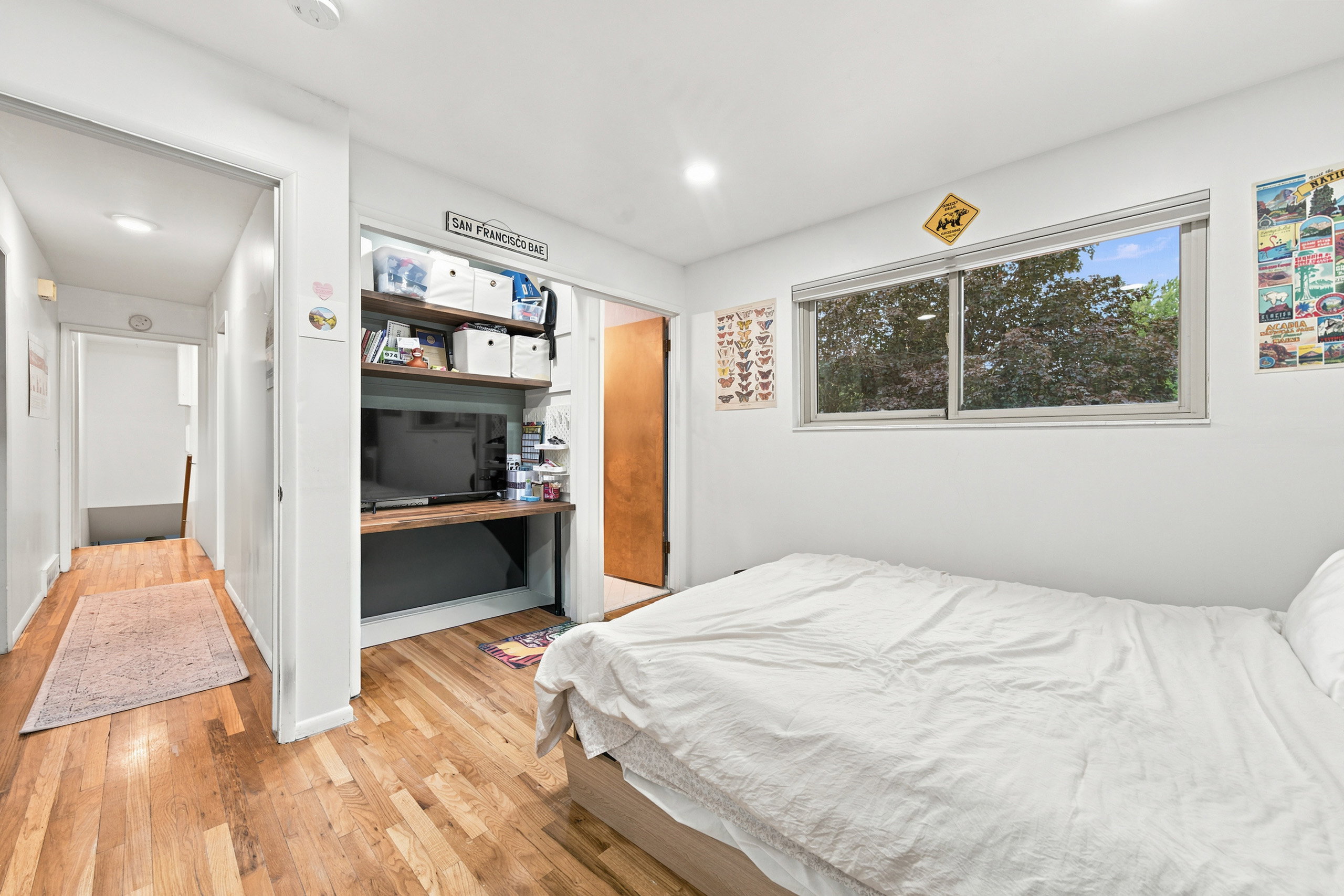 Hardwood flooring throughout, recessed lighting, and a built-in desk with shelving