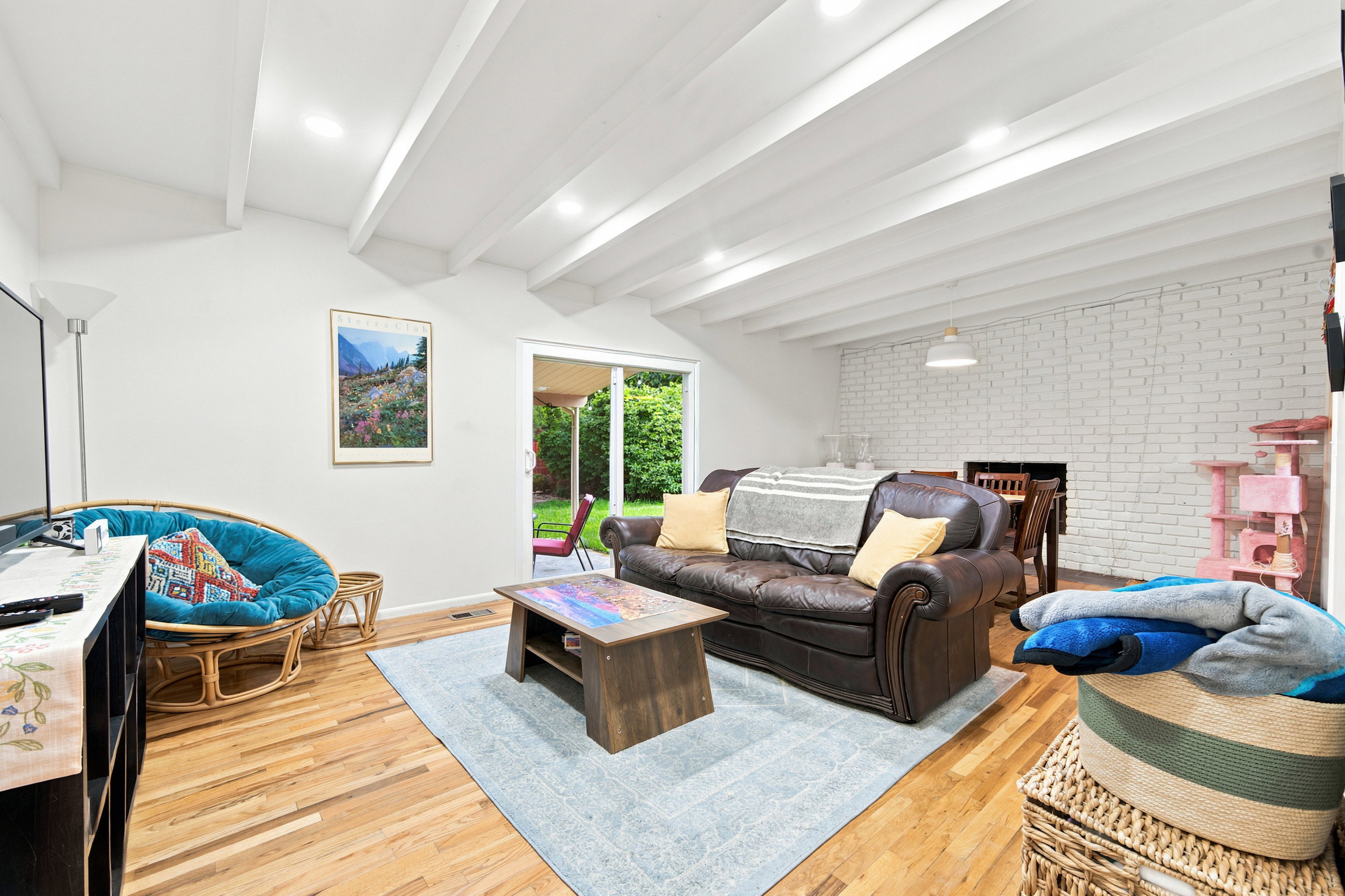 Living area with exposed beam ceiling and recessed lighting