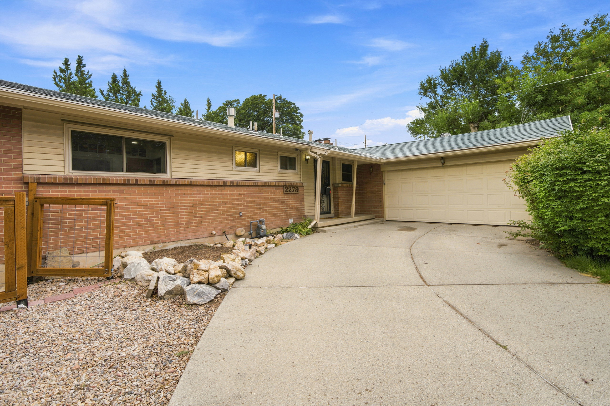 Brick and siding exterior with an attached garage and a concrete driveway