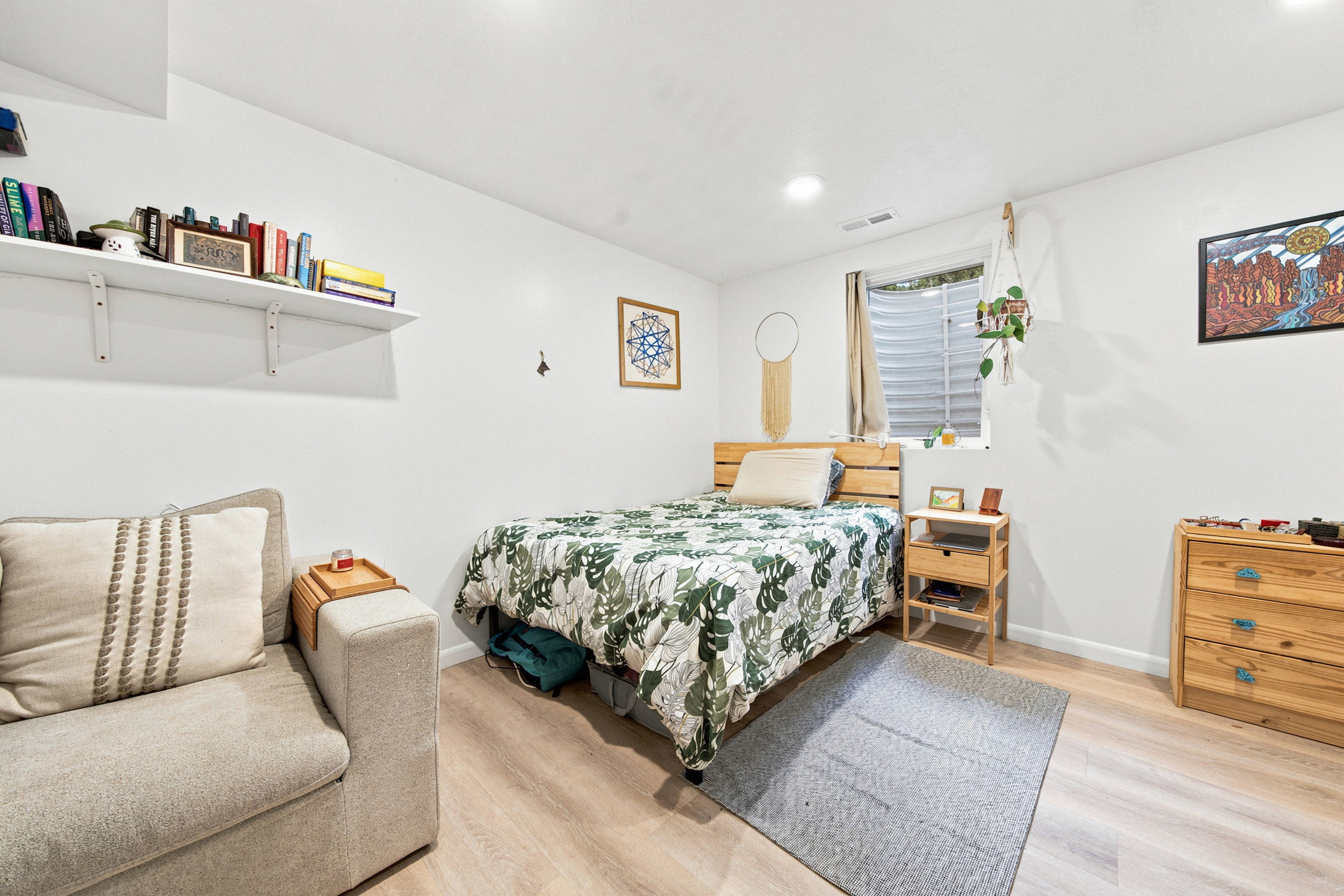Bright bedroom featuring recessed lighting, a window with horizontal blinds, and wood-finish flooring