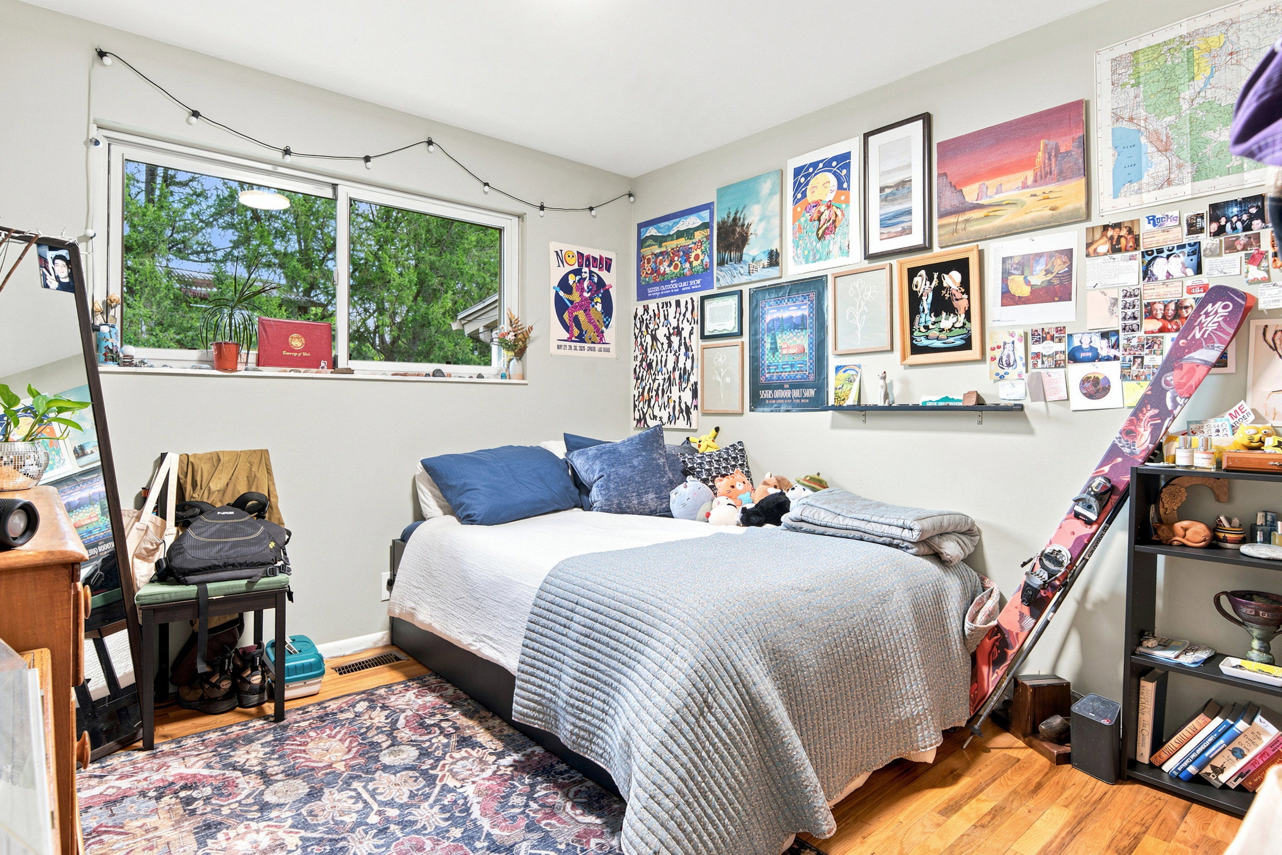 Bedroom featuring light gray walls, wood-finish flooring, and a large window providing ample natural light