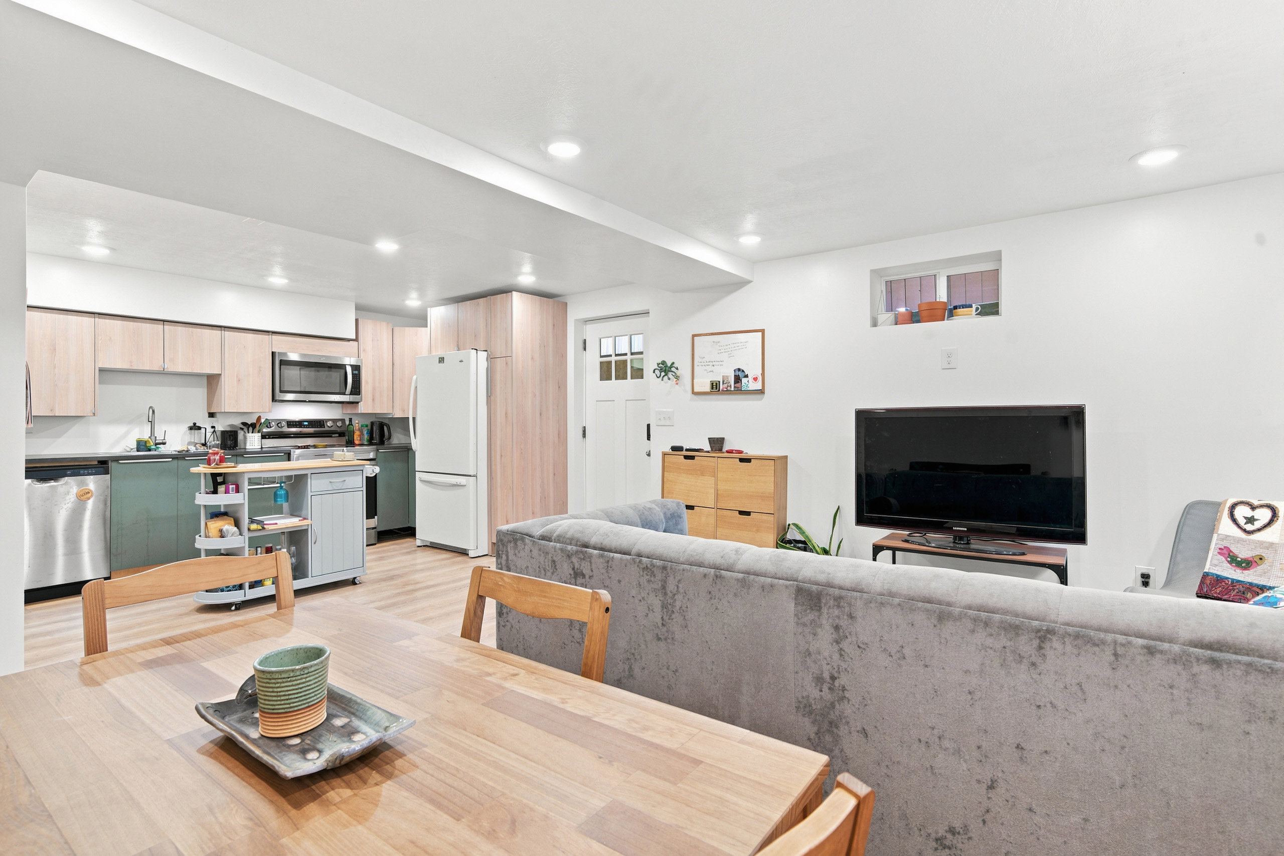 Open-concept living space featuring recessed lighting, light wood-finish flooring, and a kitchen with two-tone cabinetry