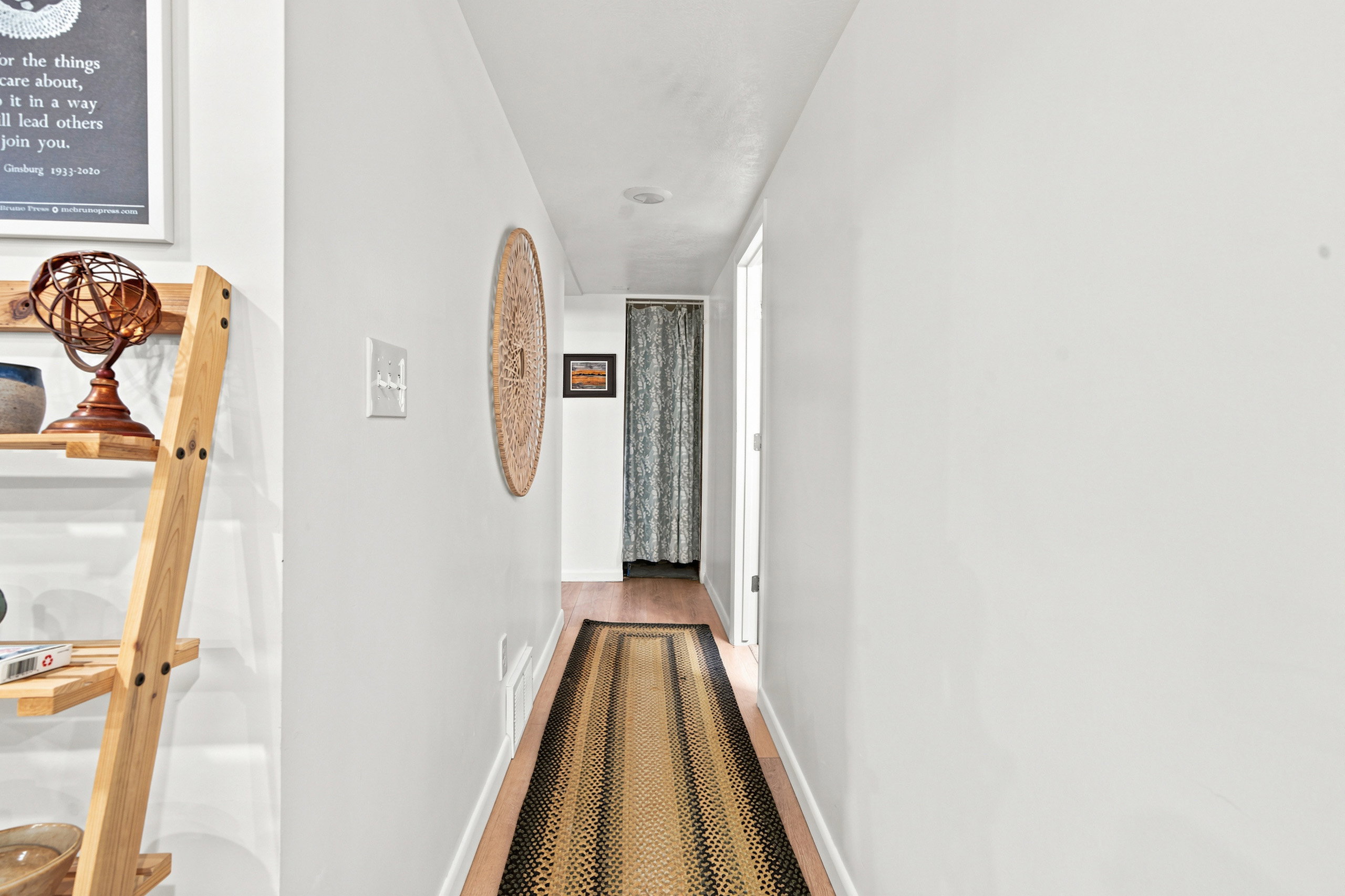 Hallway featuring light wood-finish flooring, recessed ceiling lighting, and a white interior door