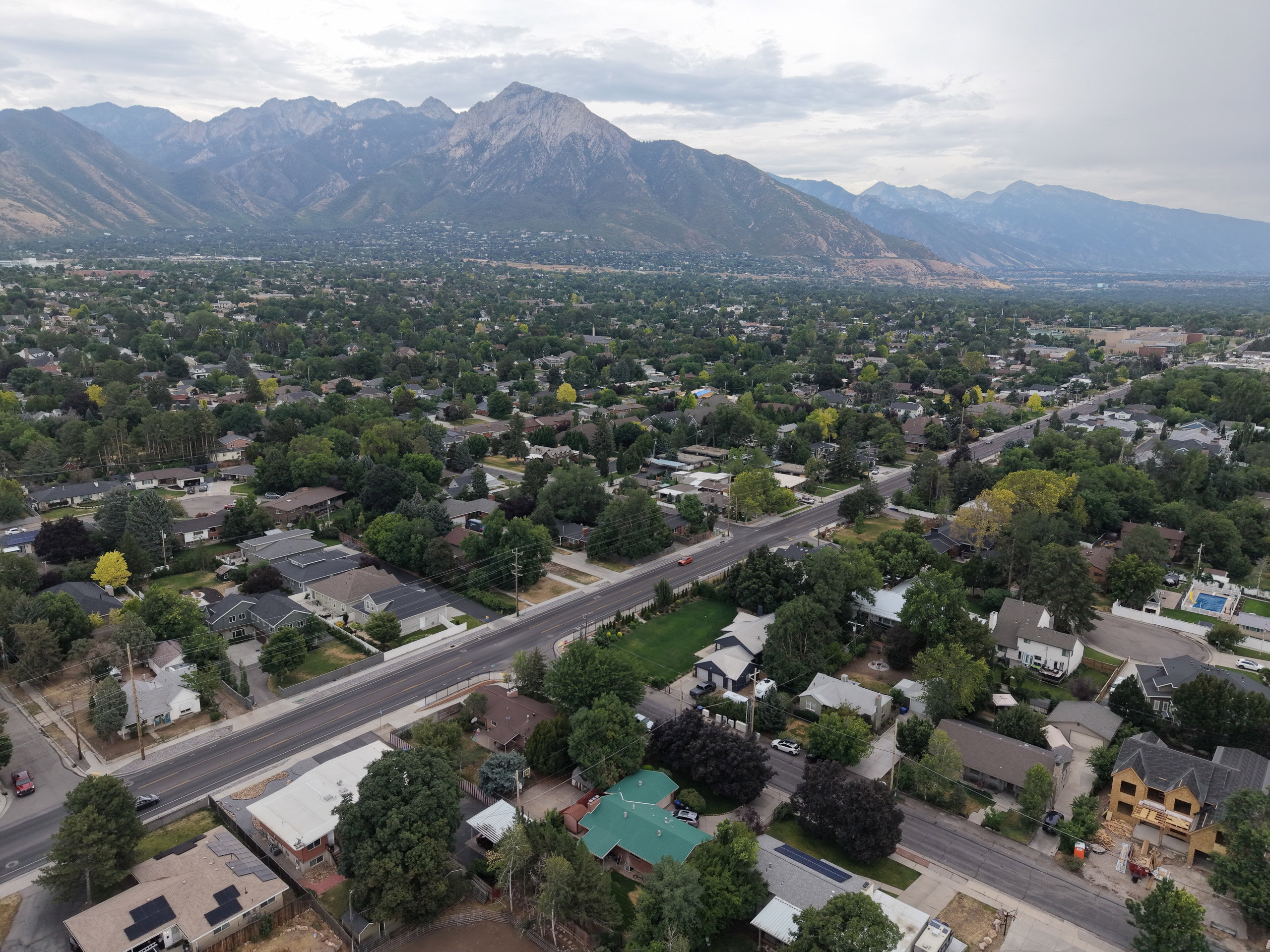 Expansive aerial capture showcasing a residential area with a prominent mountain range backdrop