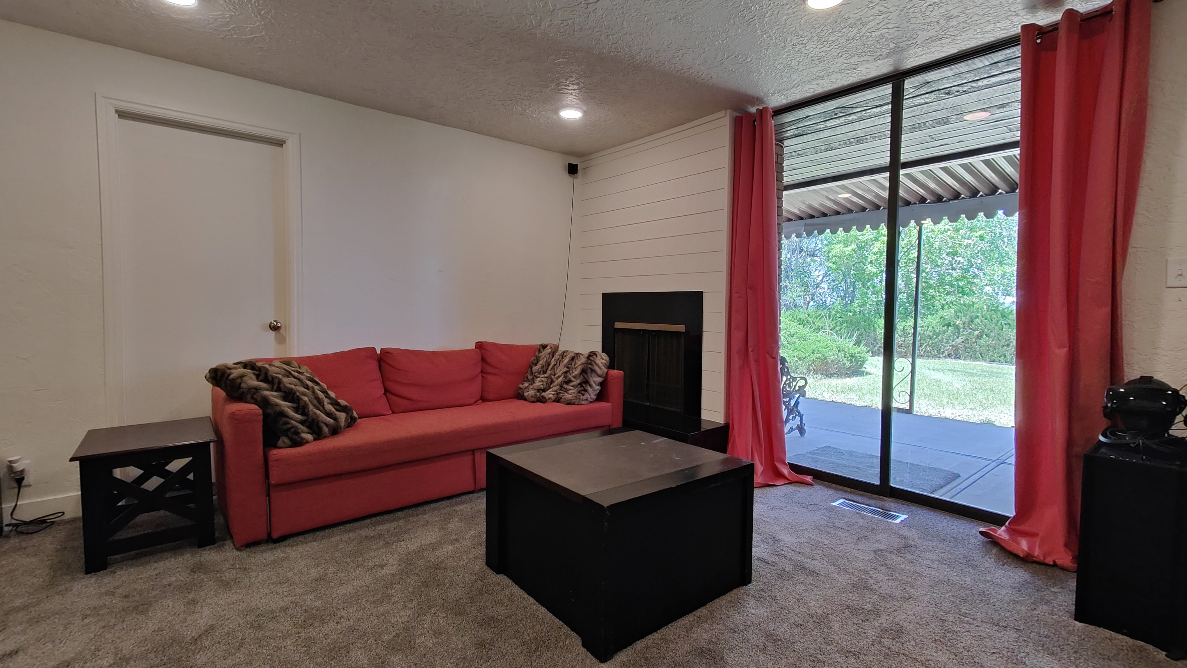 Living space featuring recessed lighting, a fireplace with a black surround, and white shiplap detailing
