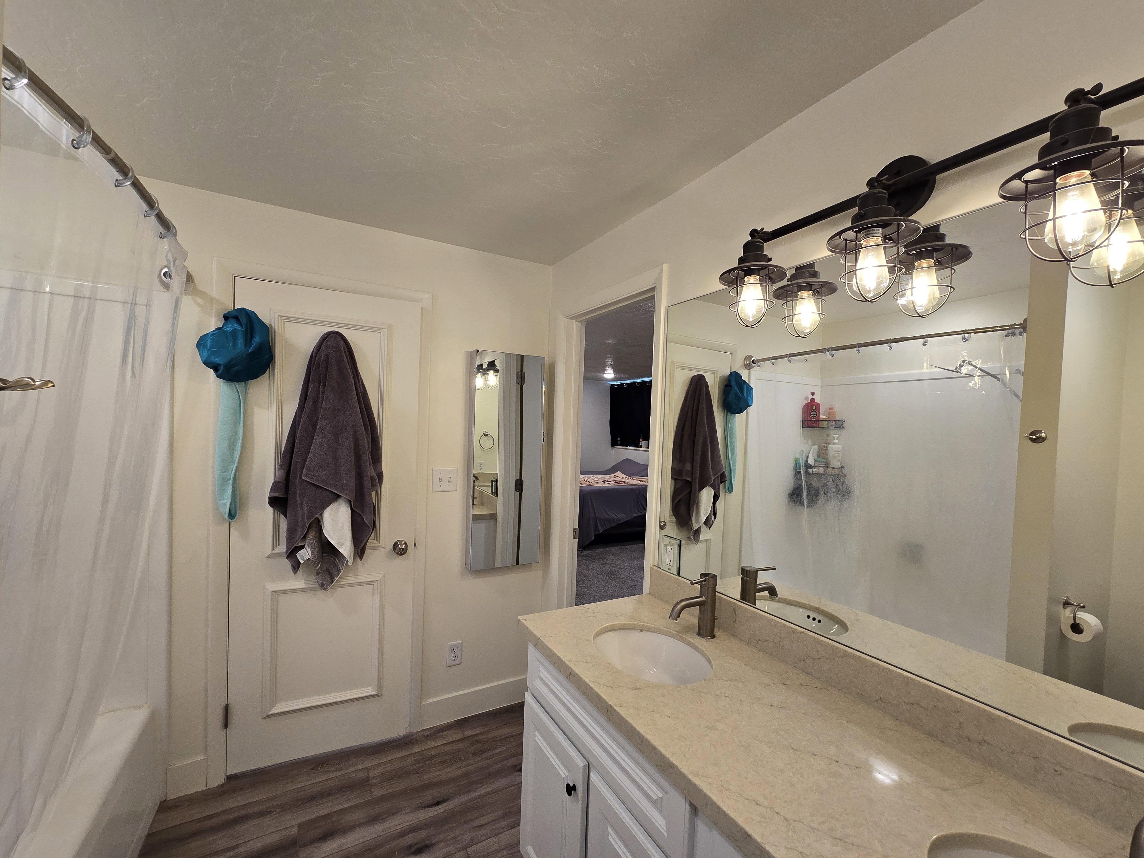 Bathroom vanity featuring a light-toned countertop, dual undermount sinks, and a full-width mirror