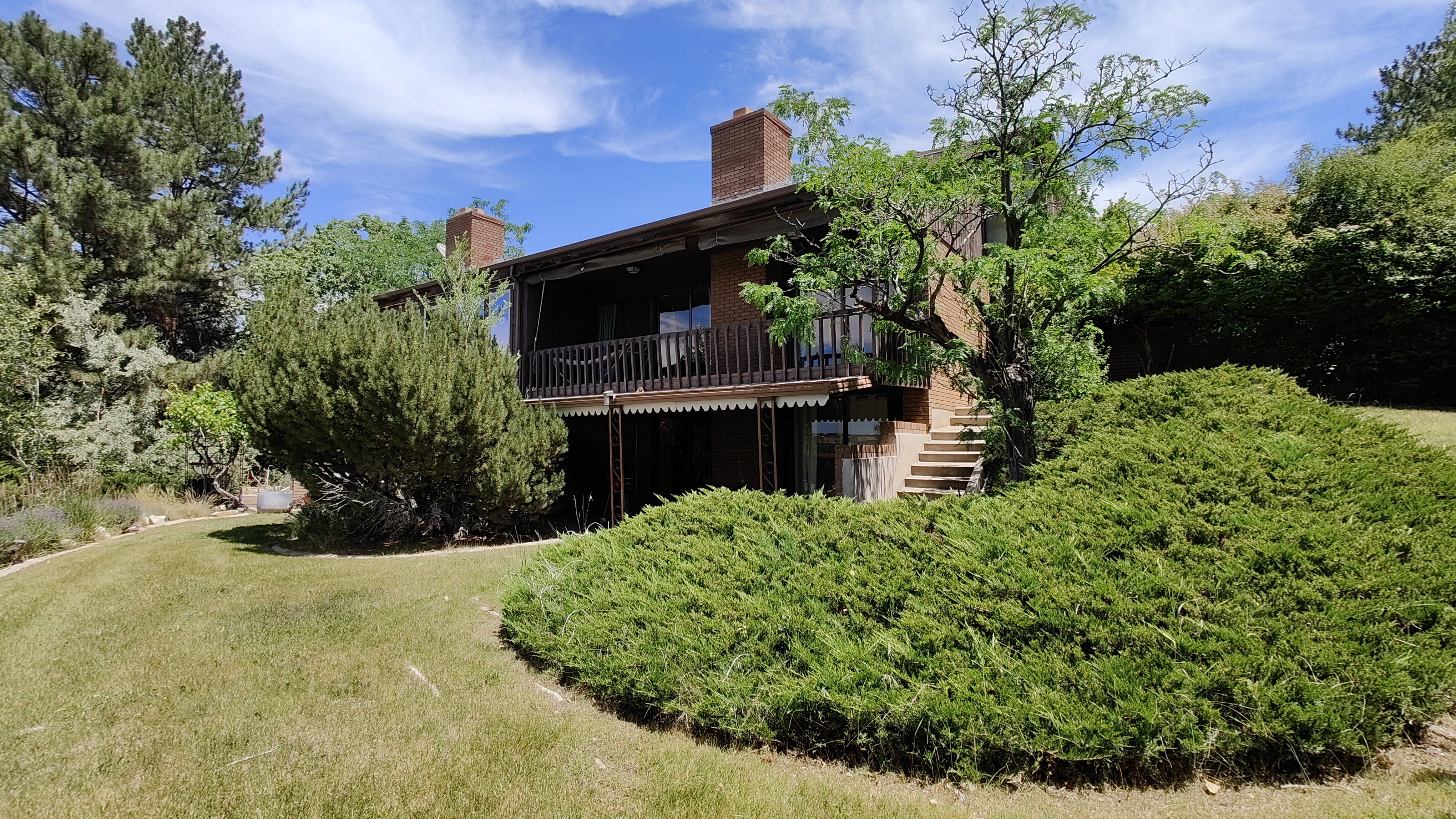 Terraced property with brick construction featuring multiple chimneys and a substantial upper-level balcony