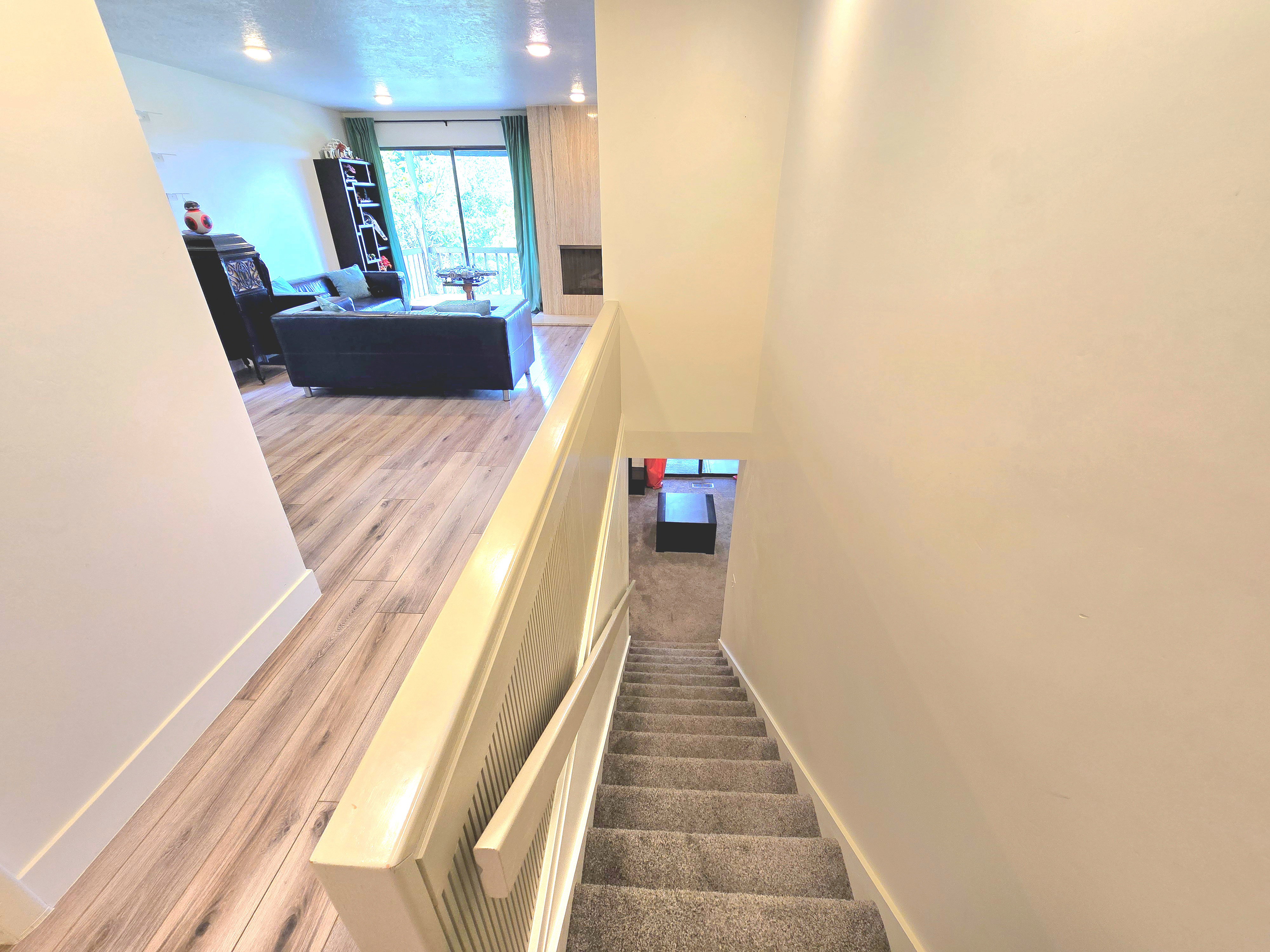 Upper level living space featuring wood-finish flooring, recessed lighting, and a fireplace with a stone surround