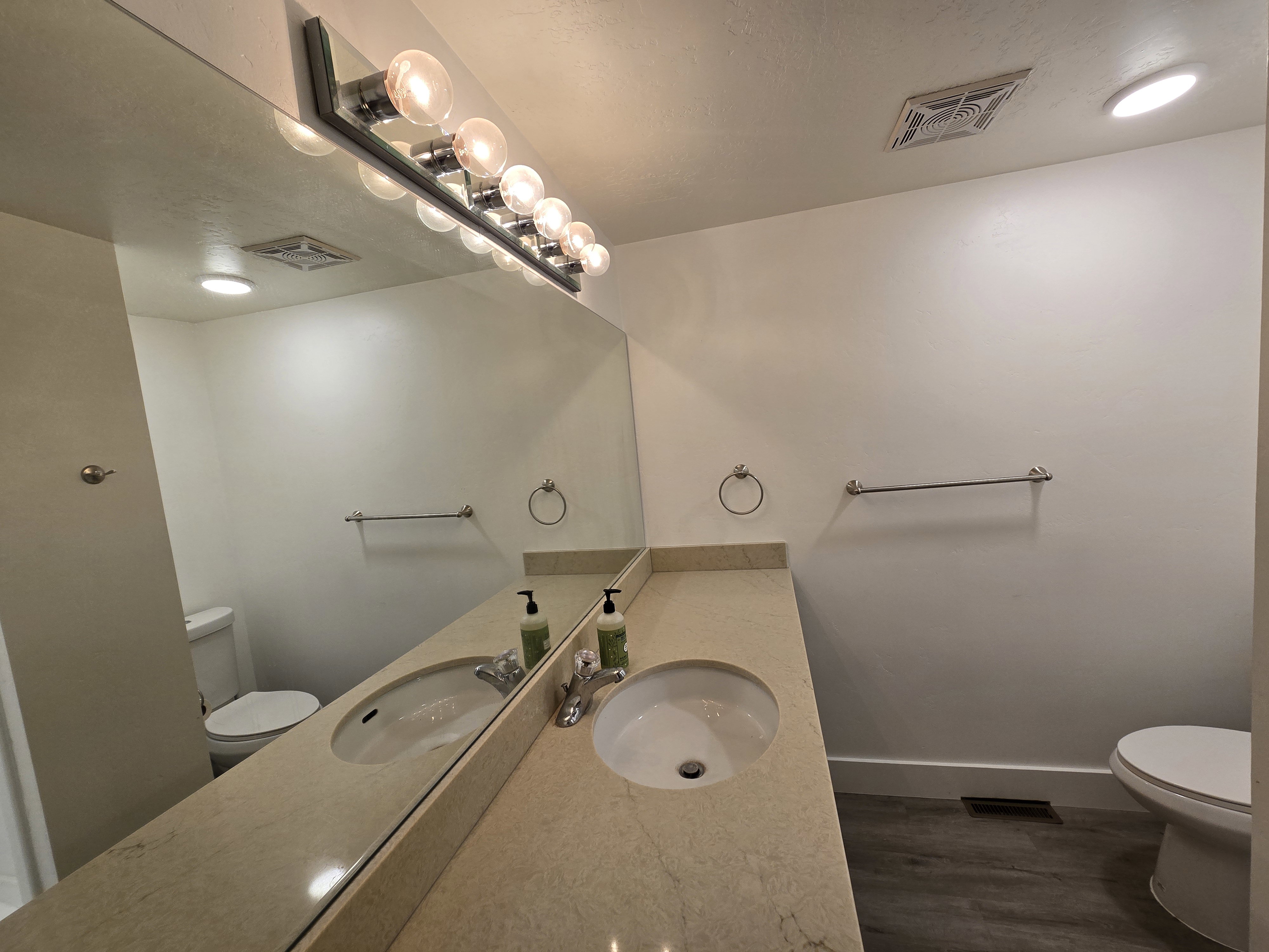 Dual vanity with integrated sinks, stone-finish countertop, and chrome fixtures