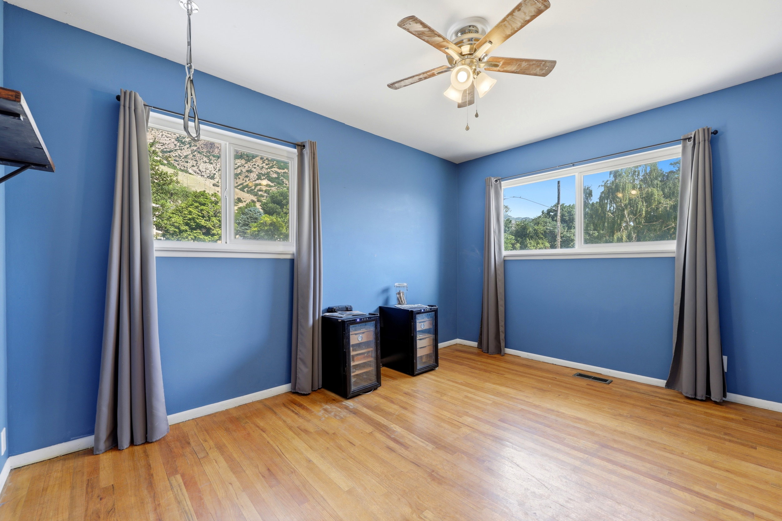 Spacious room featuring wood-finish flooring and two large windows
