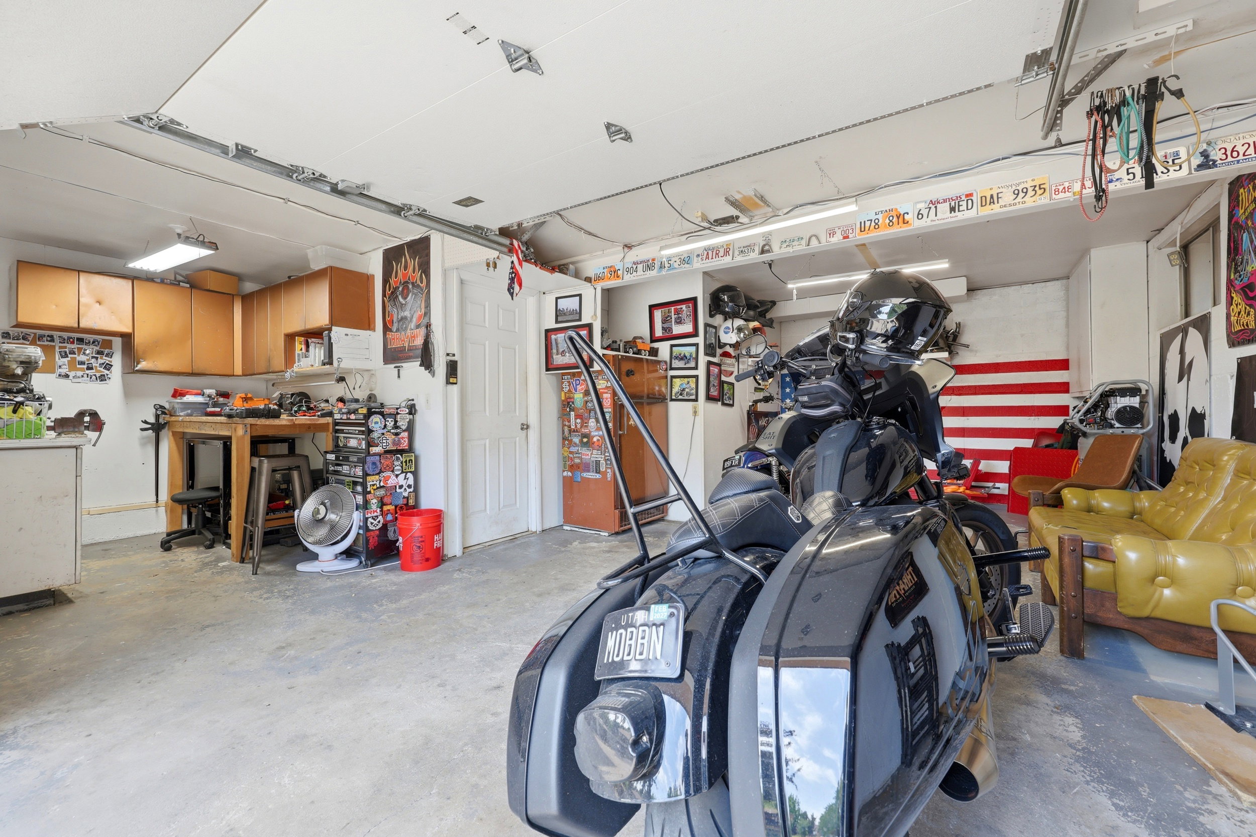 Finished garage space featuring concrete flooring, track lighting, and a built-in workbench with wood-finish cabinetry
