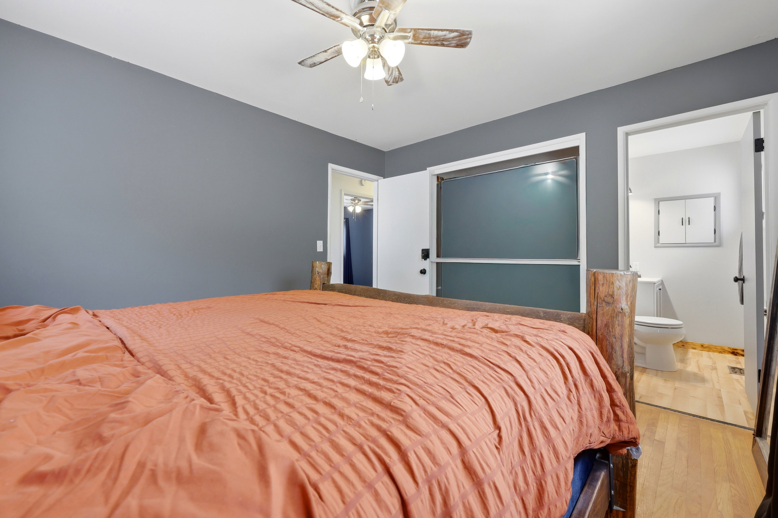 Bedroom featuring a ceiling fan, grey wall paint, and wood-finish flooring